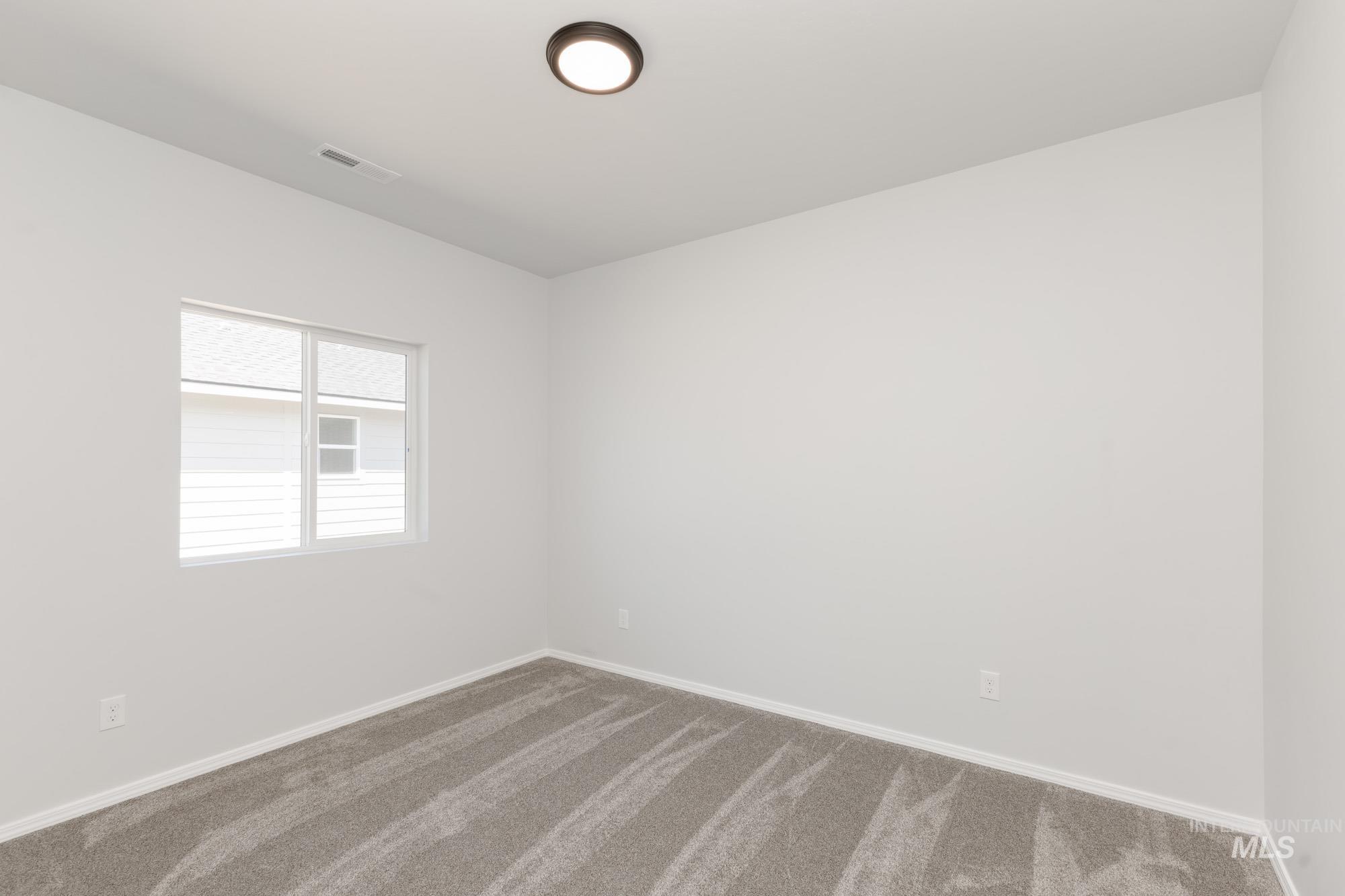 Carpeted empty room with baseboards