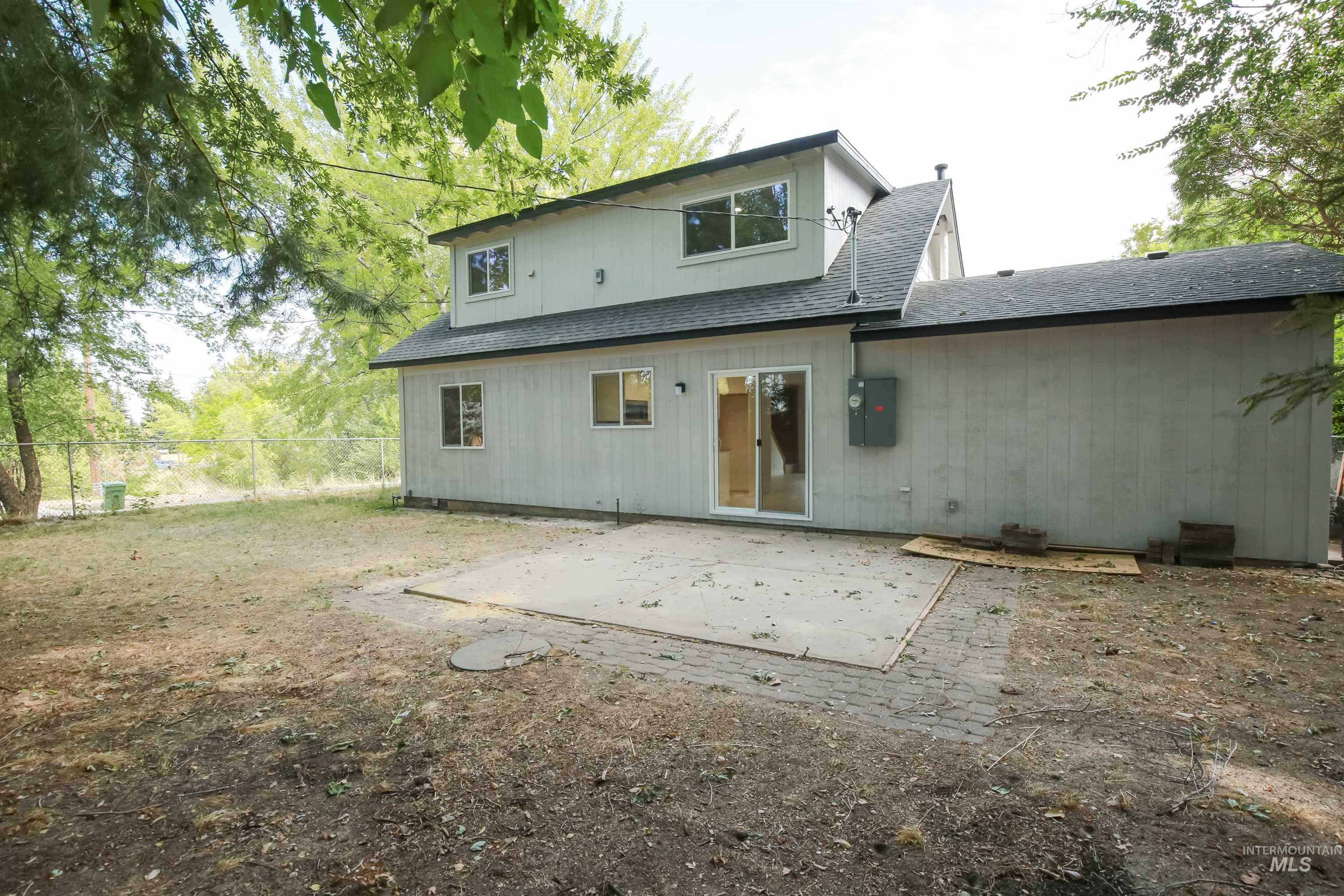 Back of property featuring a patio and roof with shingles