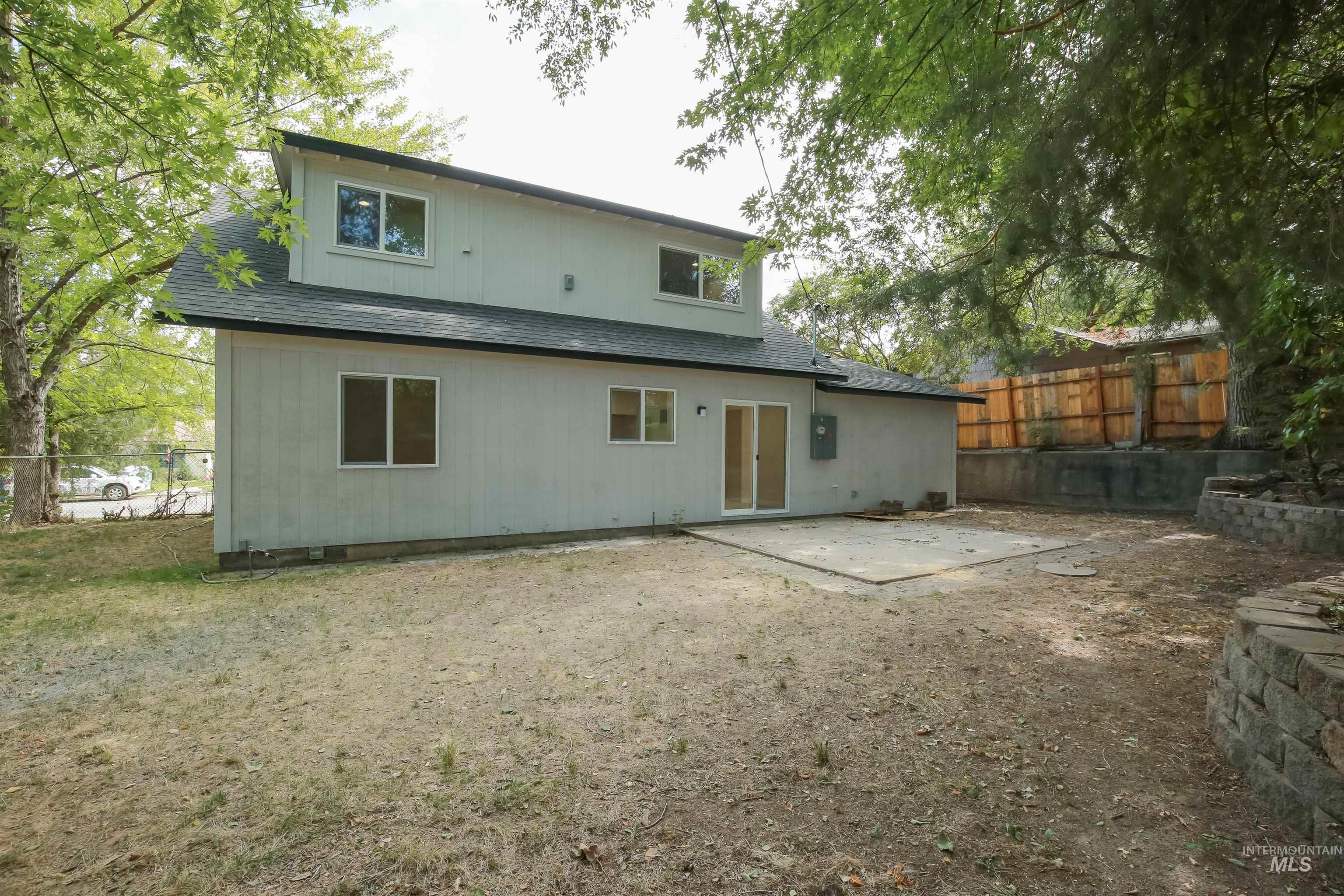 Rear view of property with a patio area and roof with shingles