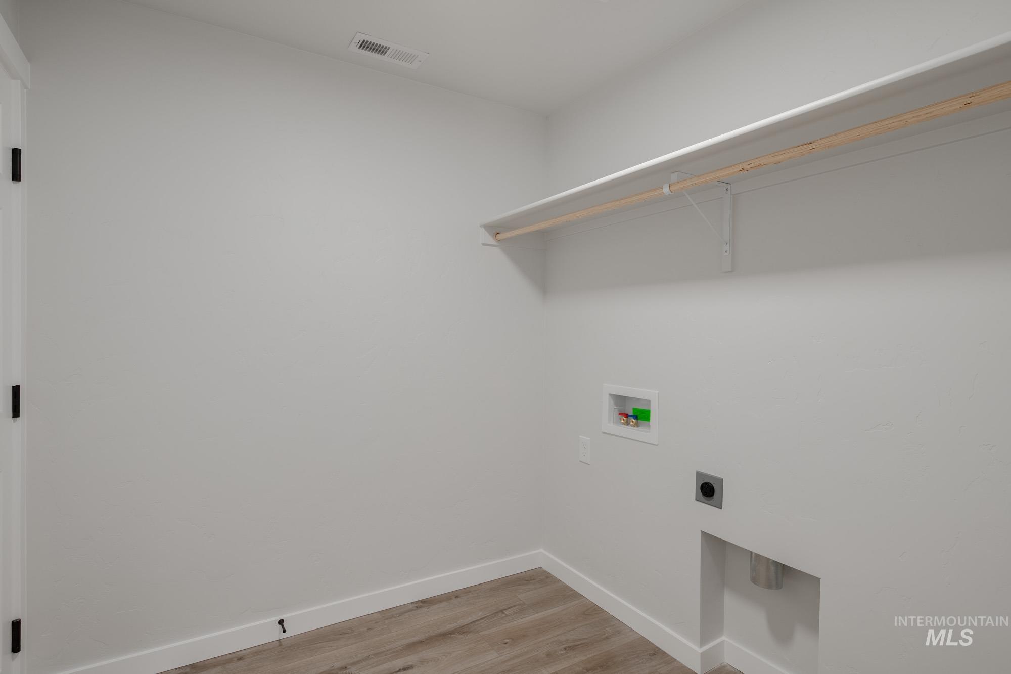 Washroom with light wood-style flooring, electric dryer hookup, and hookup for a washing machine