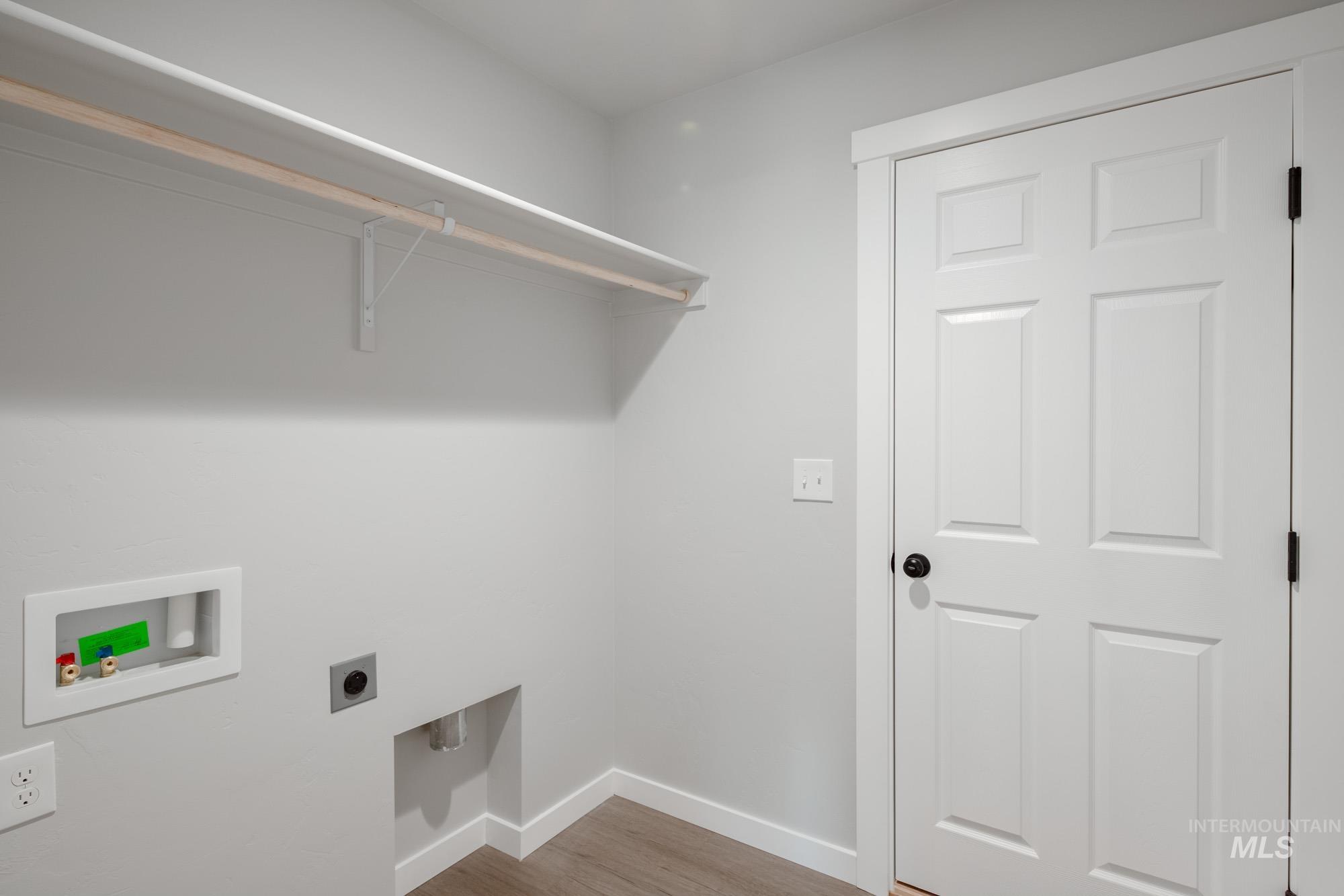 Laundry room with light wood-style flooring, hookup for a washing machine, and electric dryer hookup