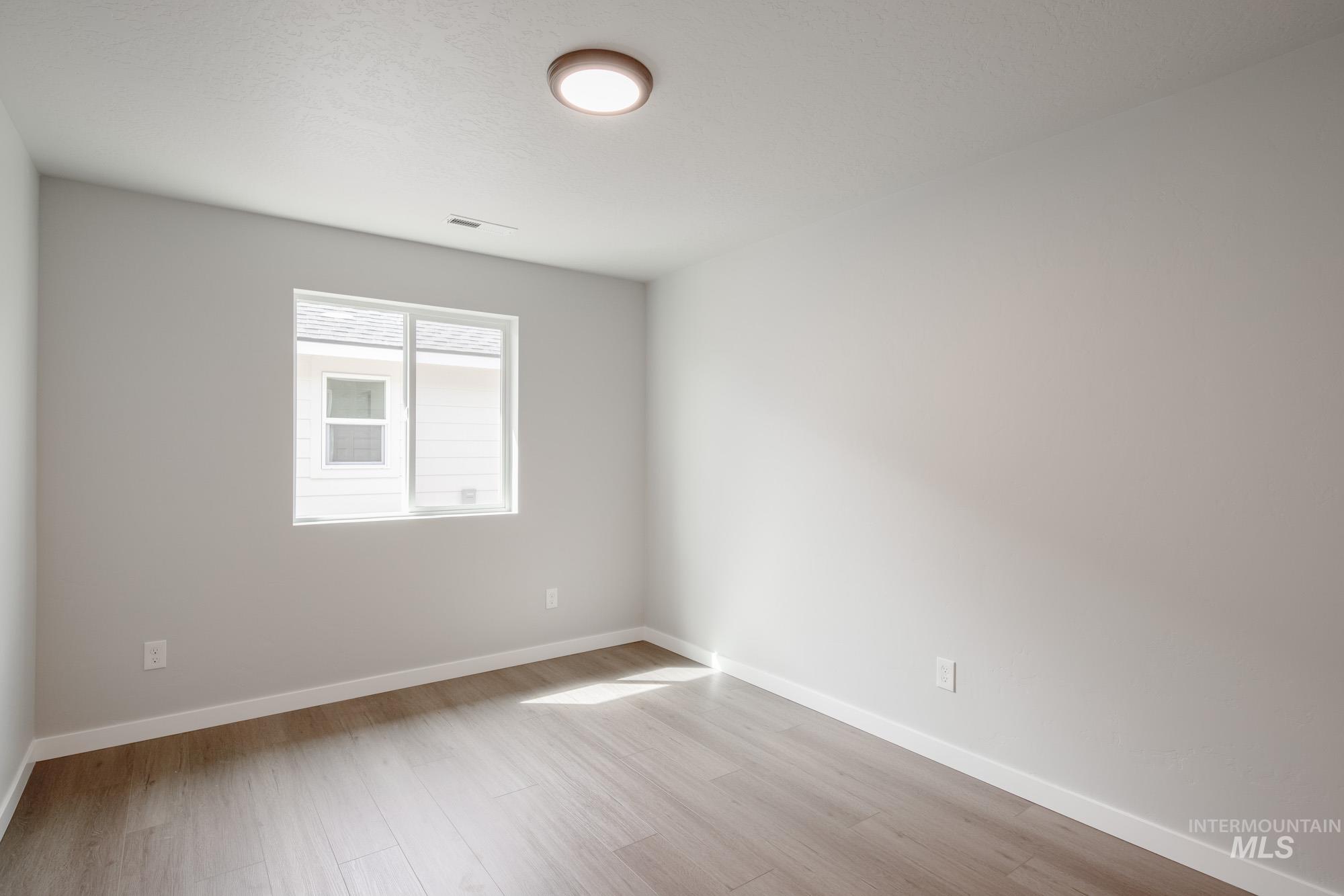 Empty room featuring baseboards and light wood-style floors