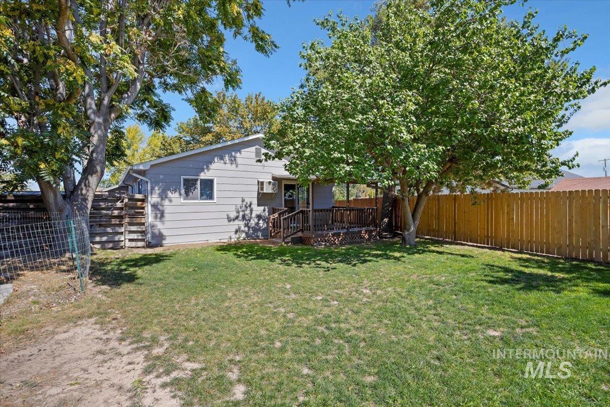 Back of property featuring a fenced backyard and a deck