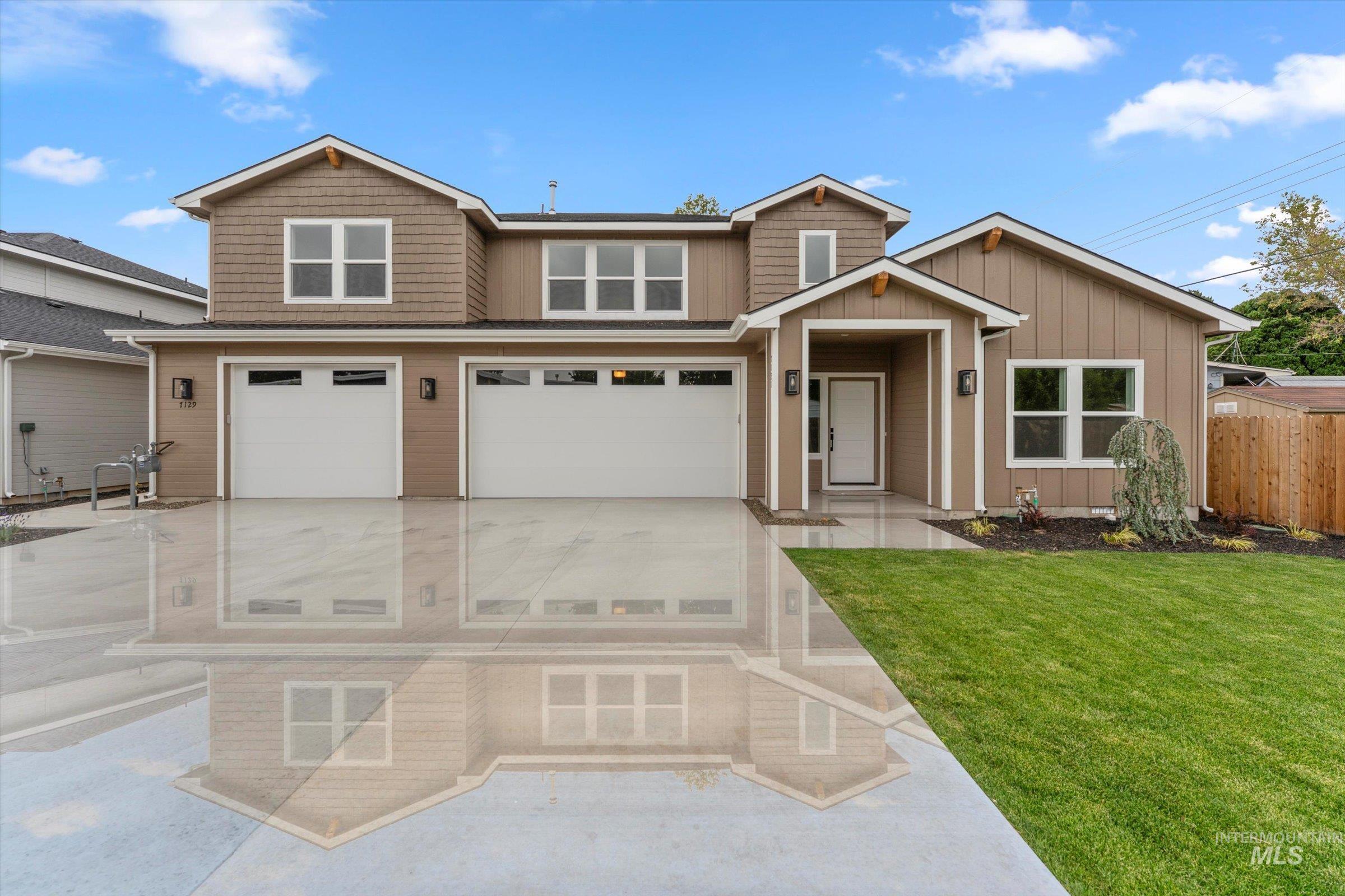 View of front of house featuring an attached garage, concrete driveway, and board and batten siding