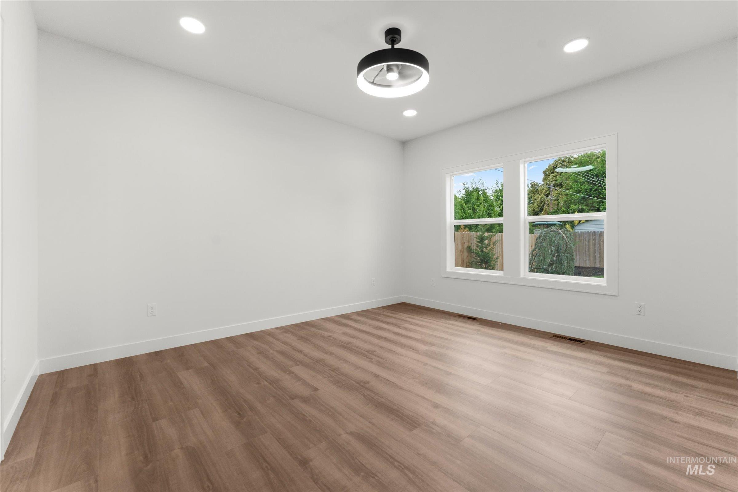 Empty room featuring light wood-style floors and recessed lighting