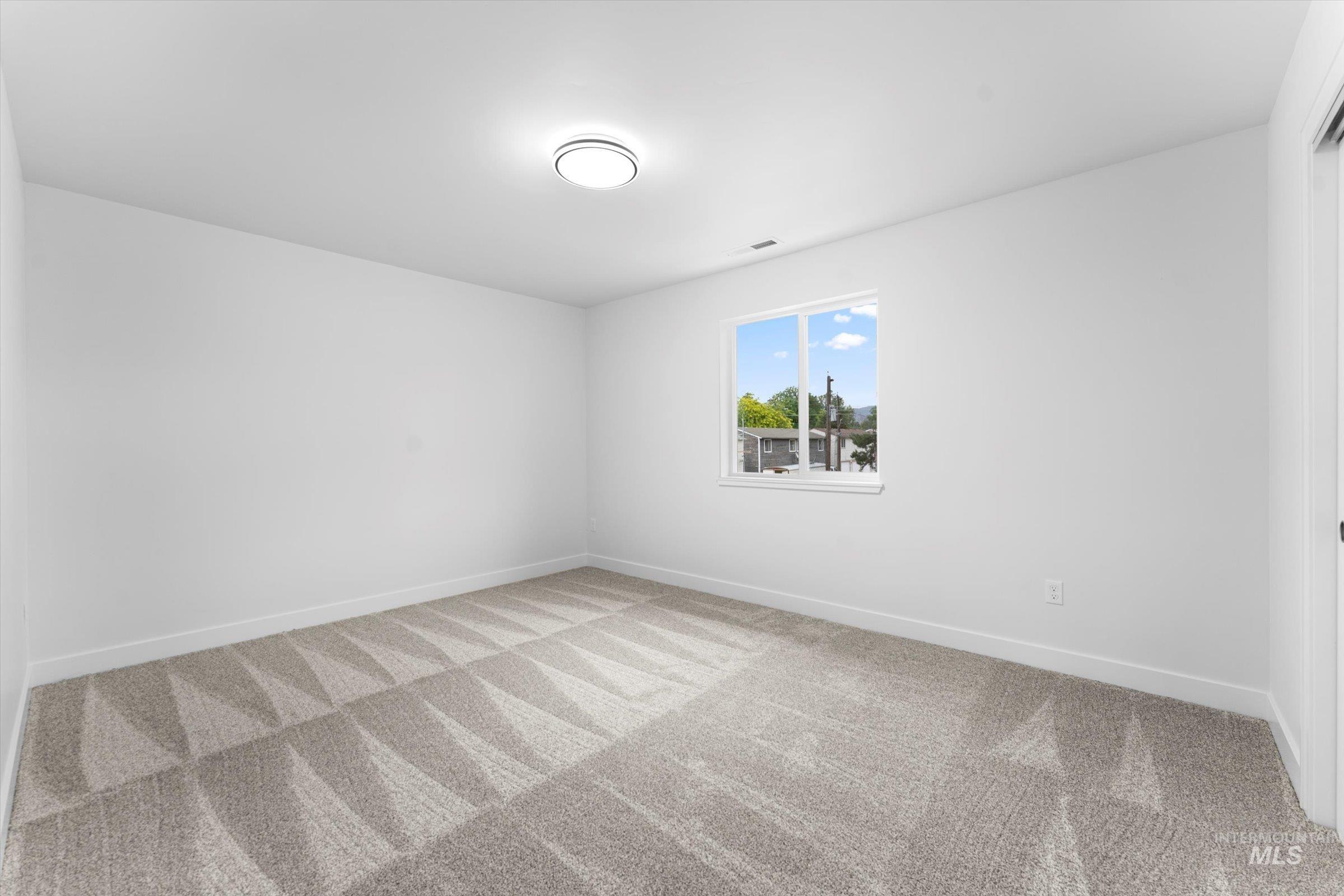Empty room with light carpet and baseboards