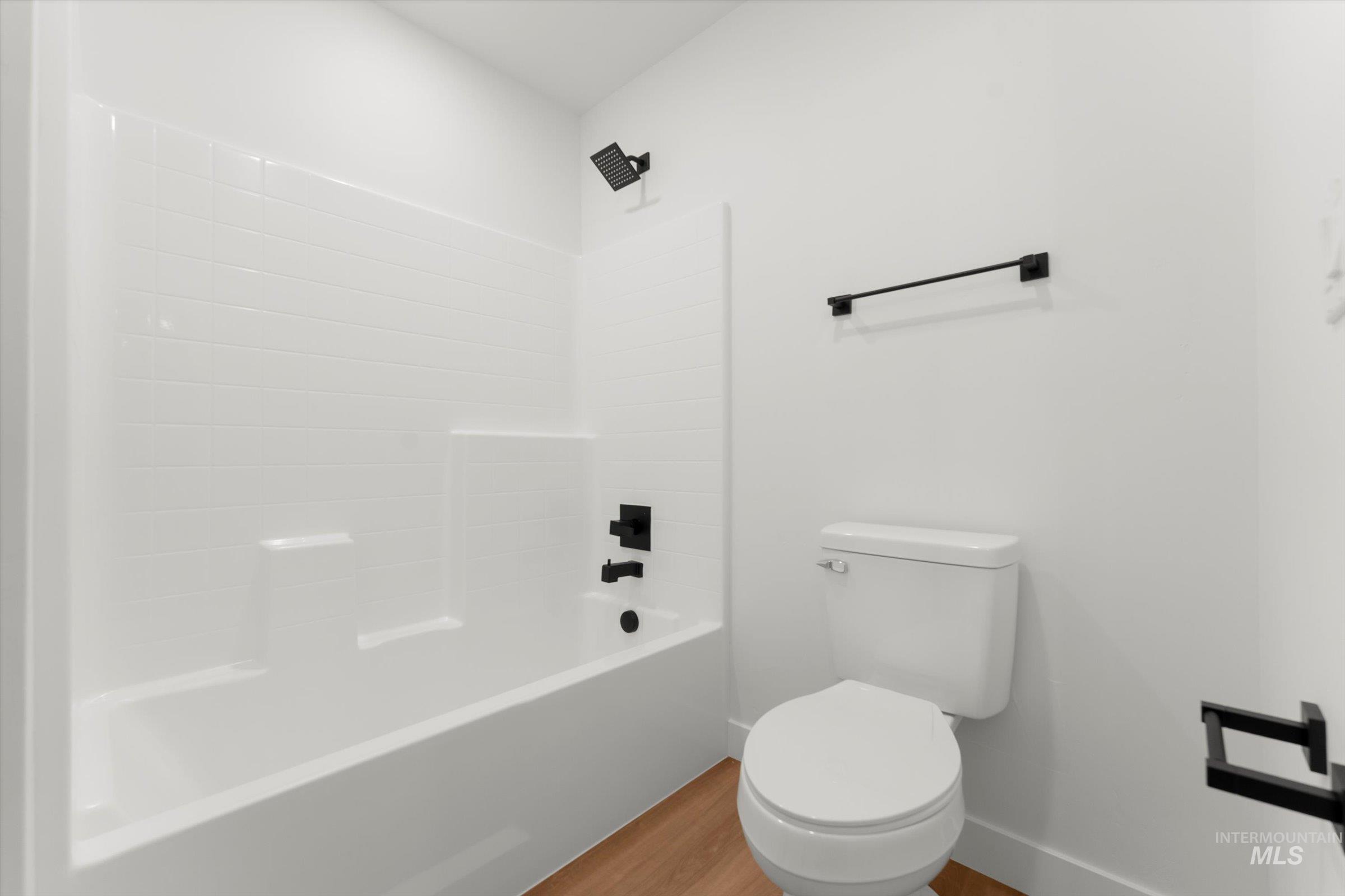 Bathroom with wood finished floors and  shower combination