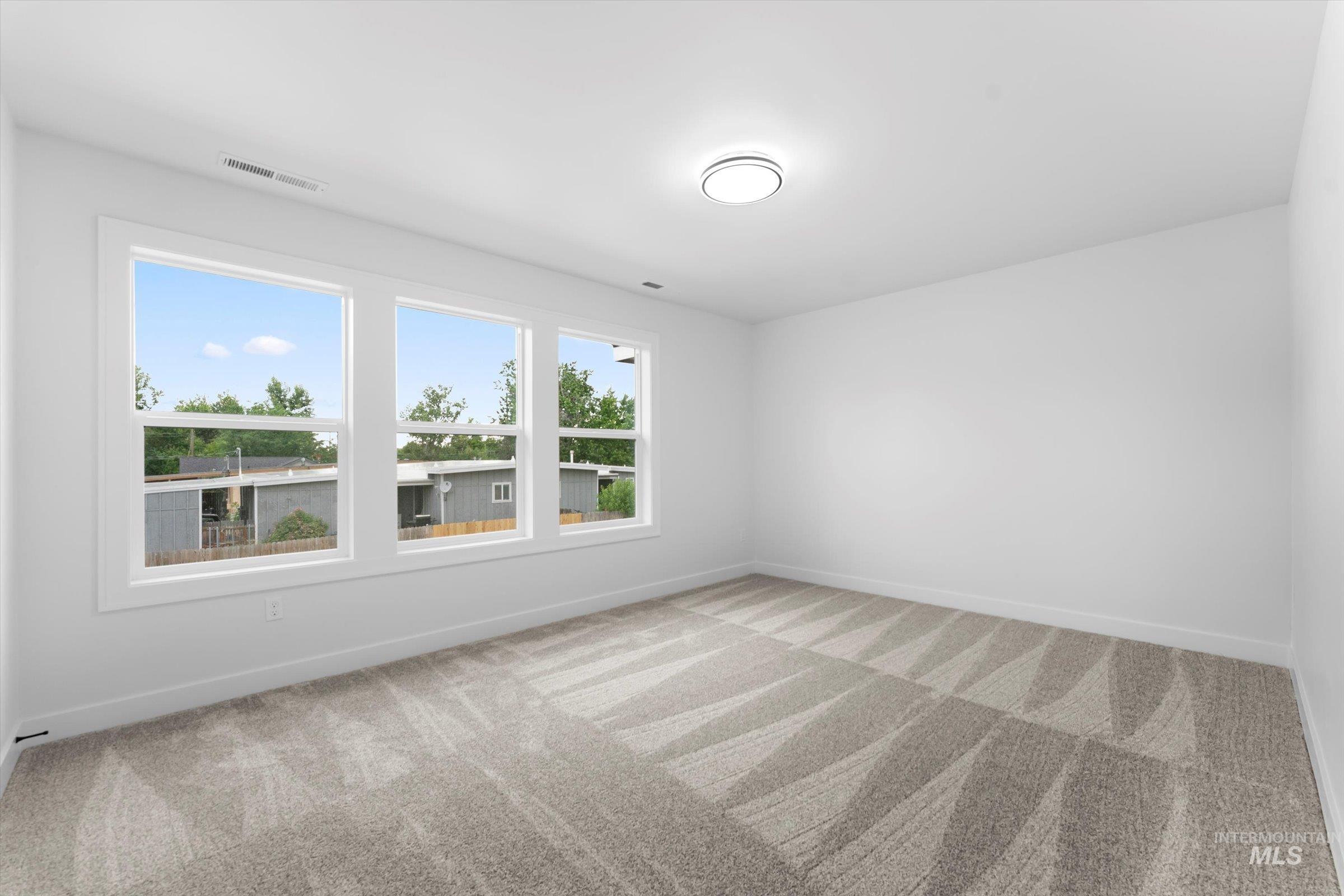Unfurnished room featuring light colored carpet and baseboards