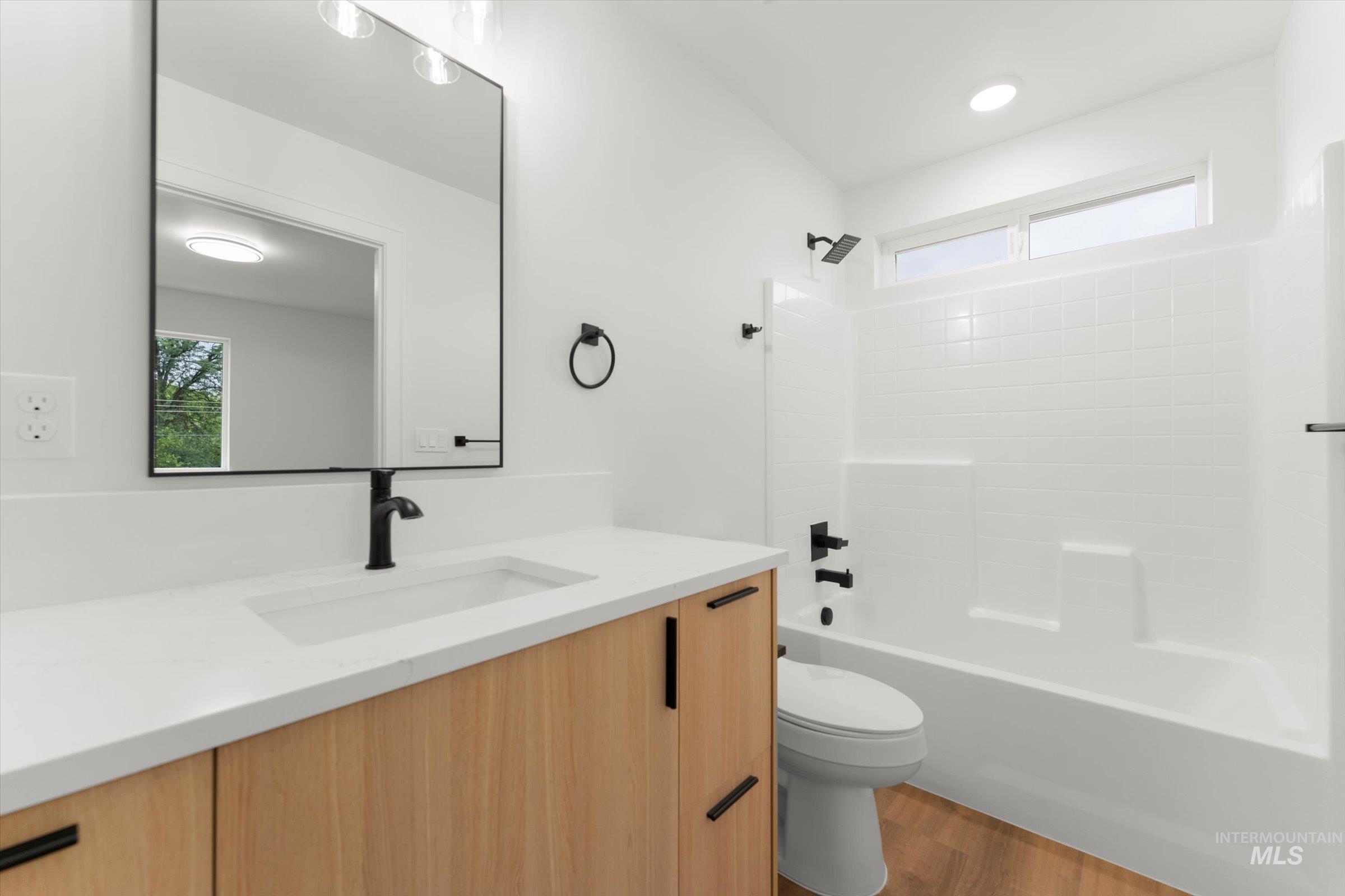 Full bath featuring vanity, shower / washtub combination, and light wood-style floors