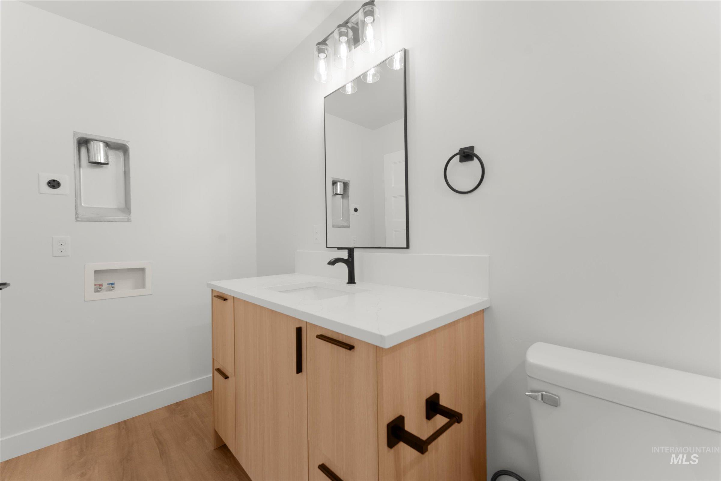 Half bath with vanity and light wood-style flooring