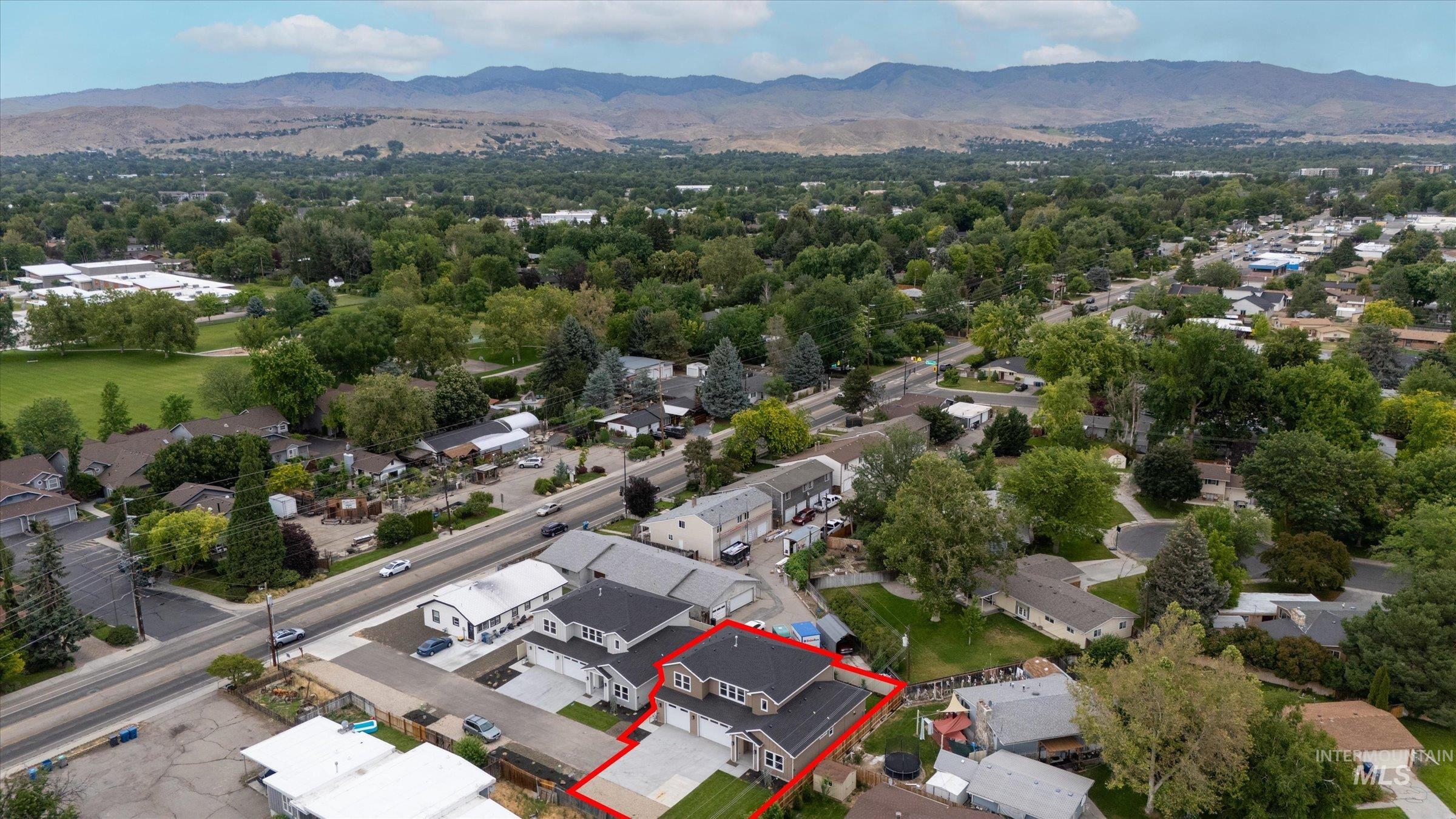 Aerial perspective of suburban area with a mountainous background and property boundaries highlighted