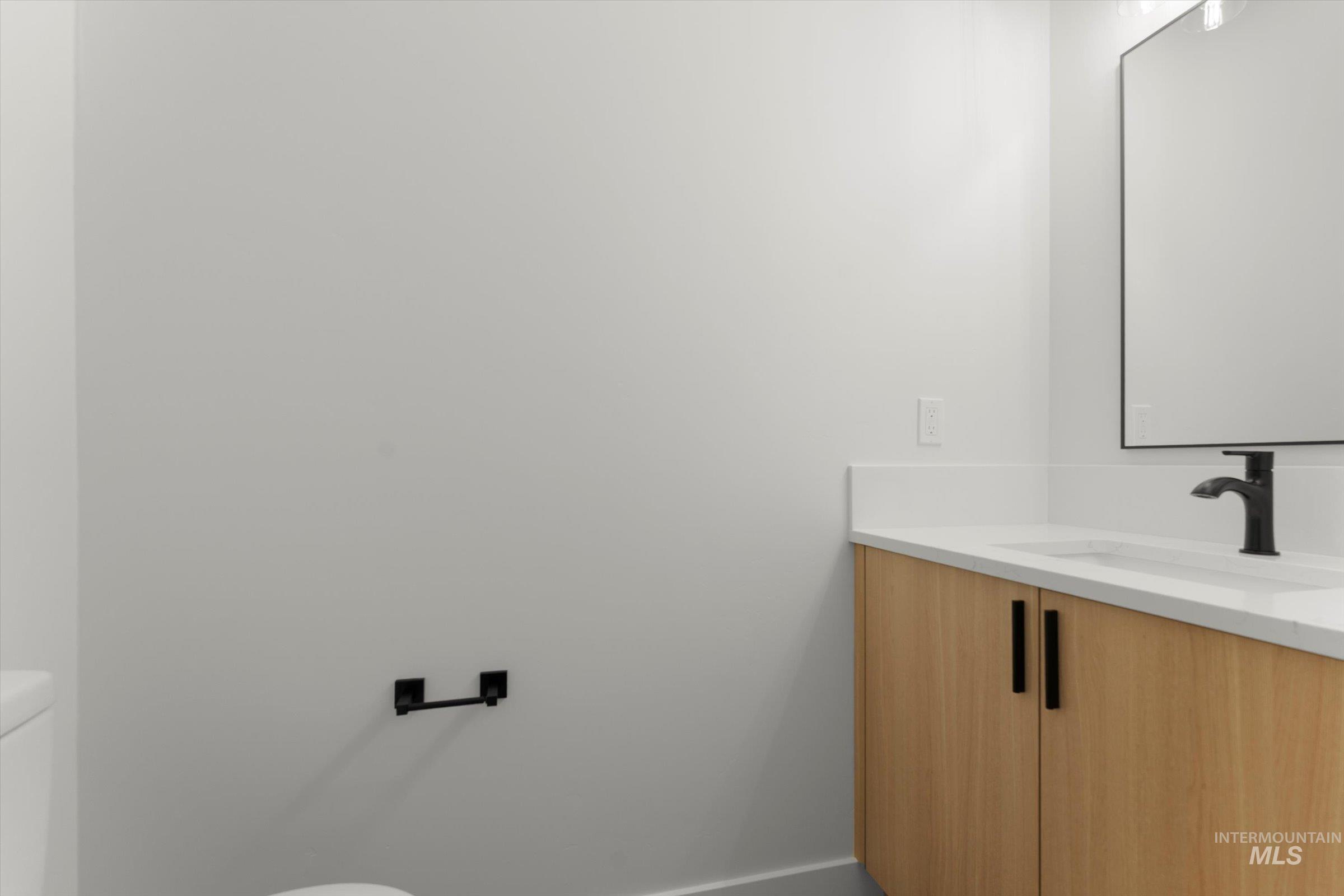 Half bath featuring toilet and vanity