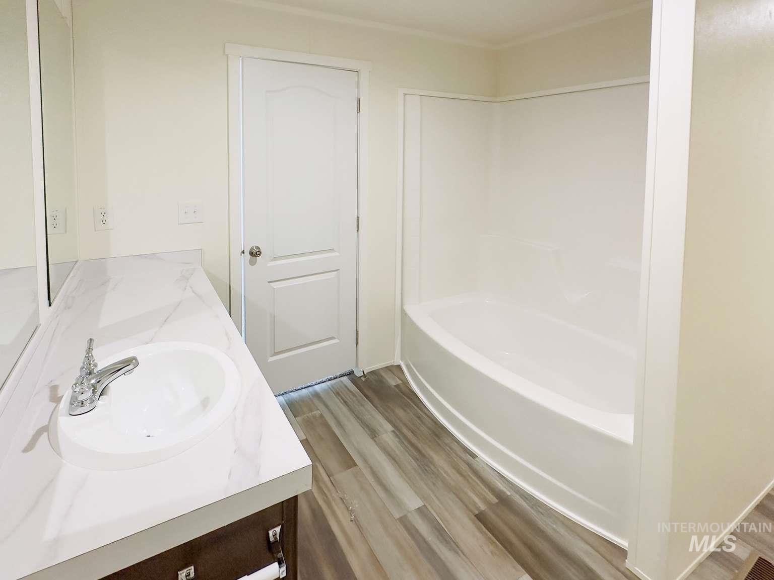 Bathroom featuring double vanity and light wood finished floors