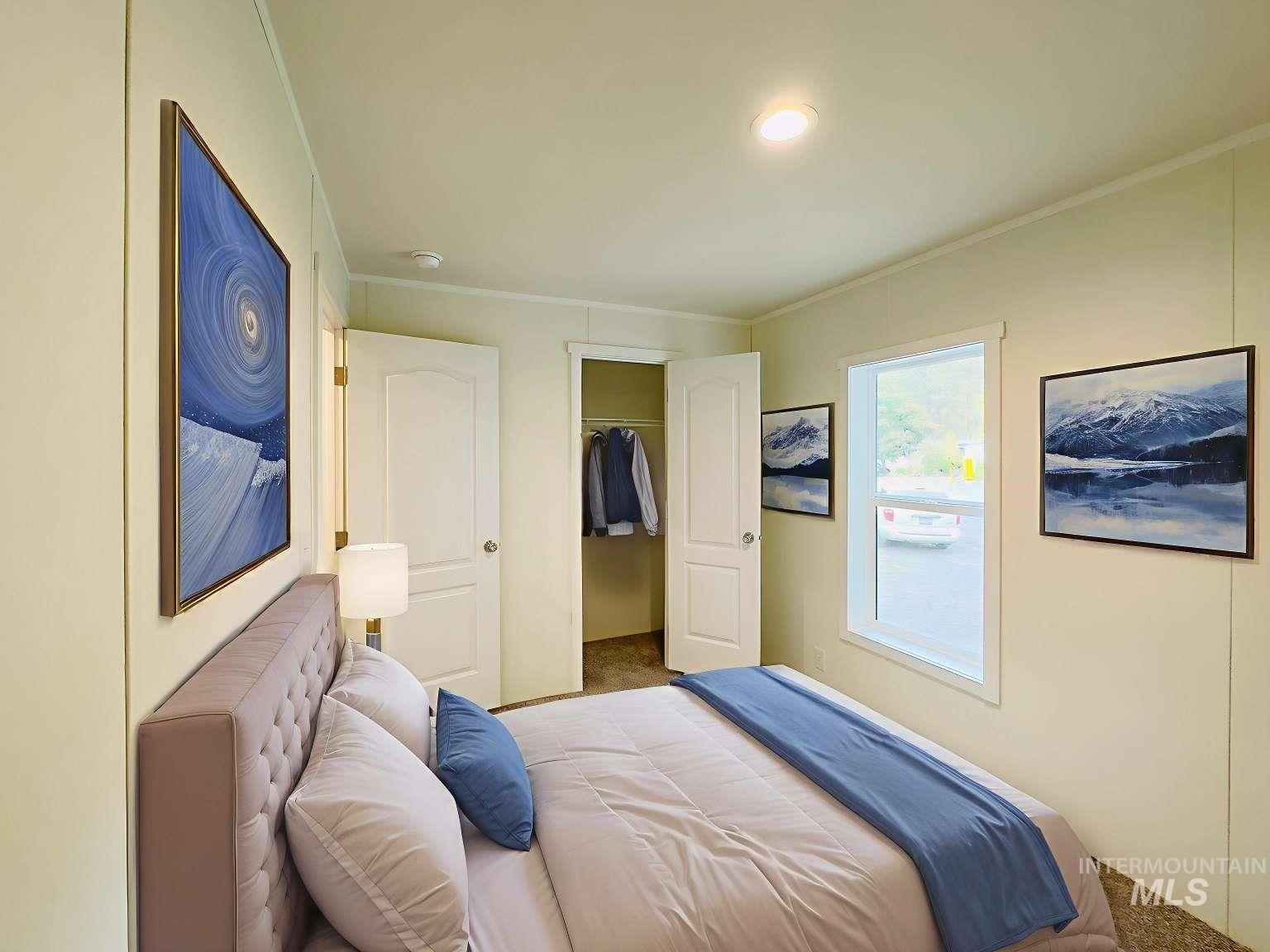 Bedroom featuring crown molding, carpet floors, and a walk in closet