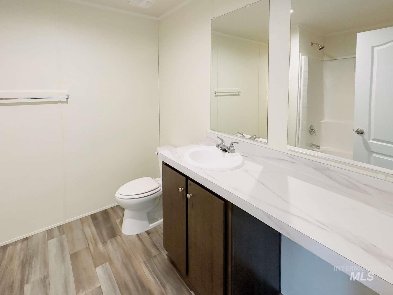 Full bathroom with  shower combination, light wood-style flooring, and vanity