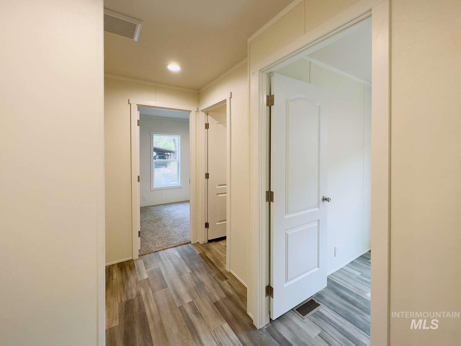 Hallway with light wood-style floors, recessed lighting, and crown molding