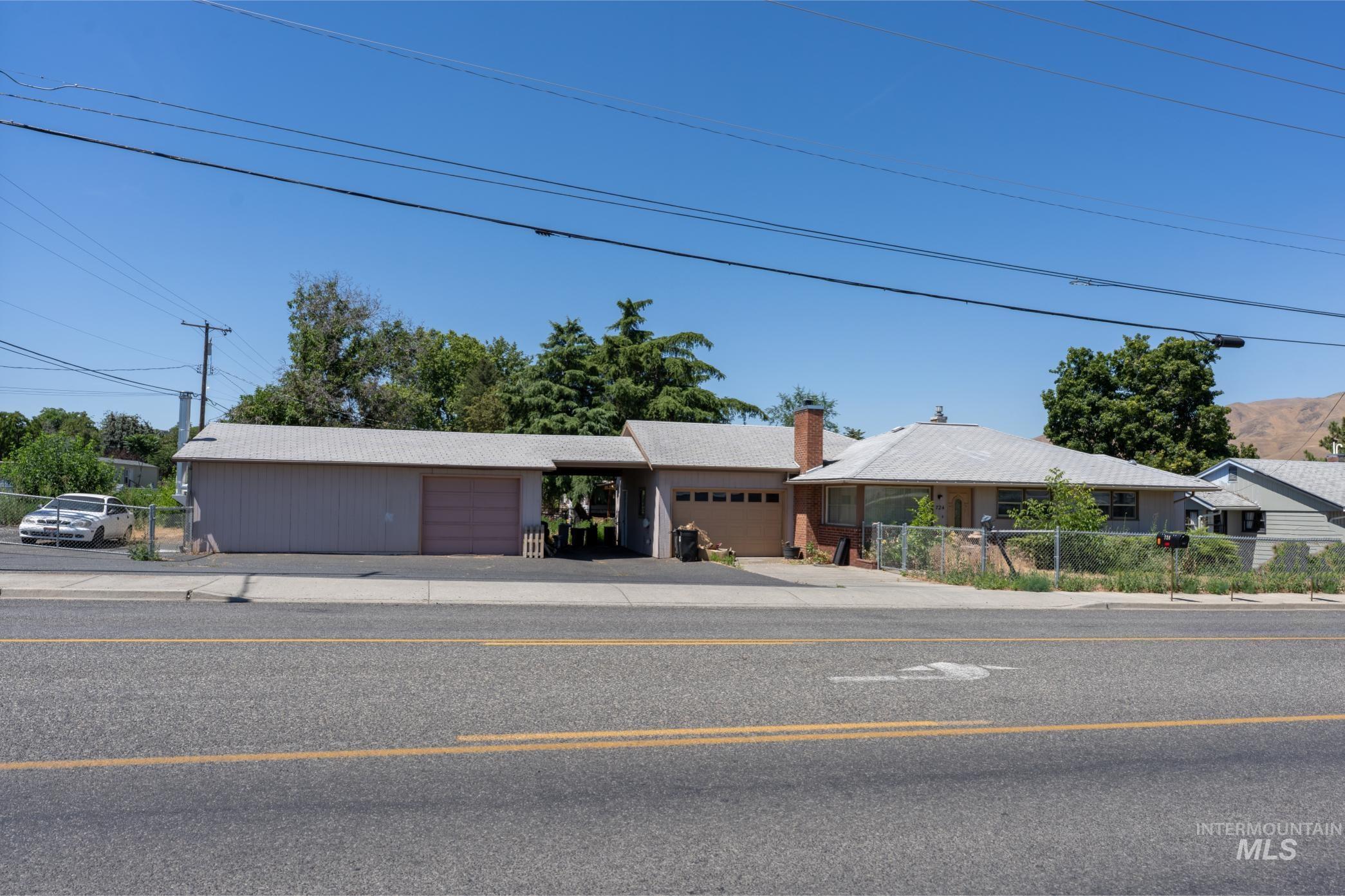 Ranch-style house with a chimney, an attached garage, and driveway