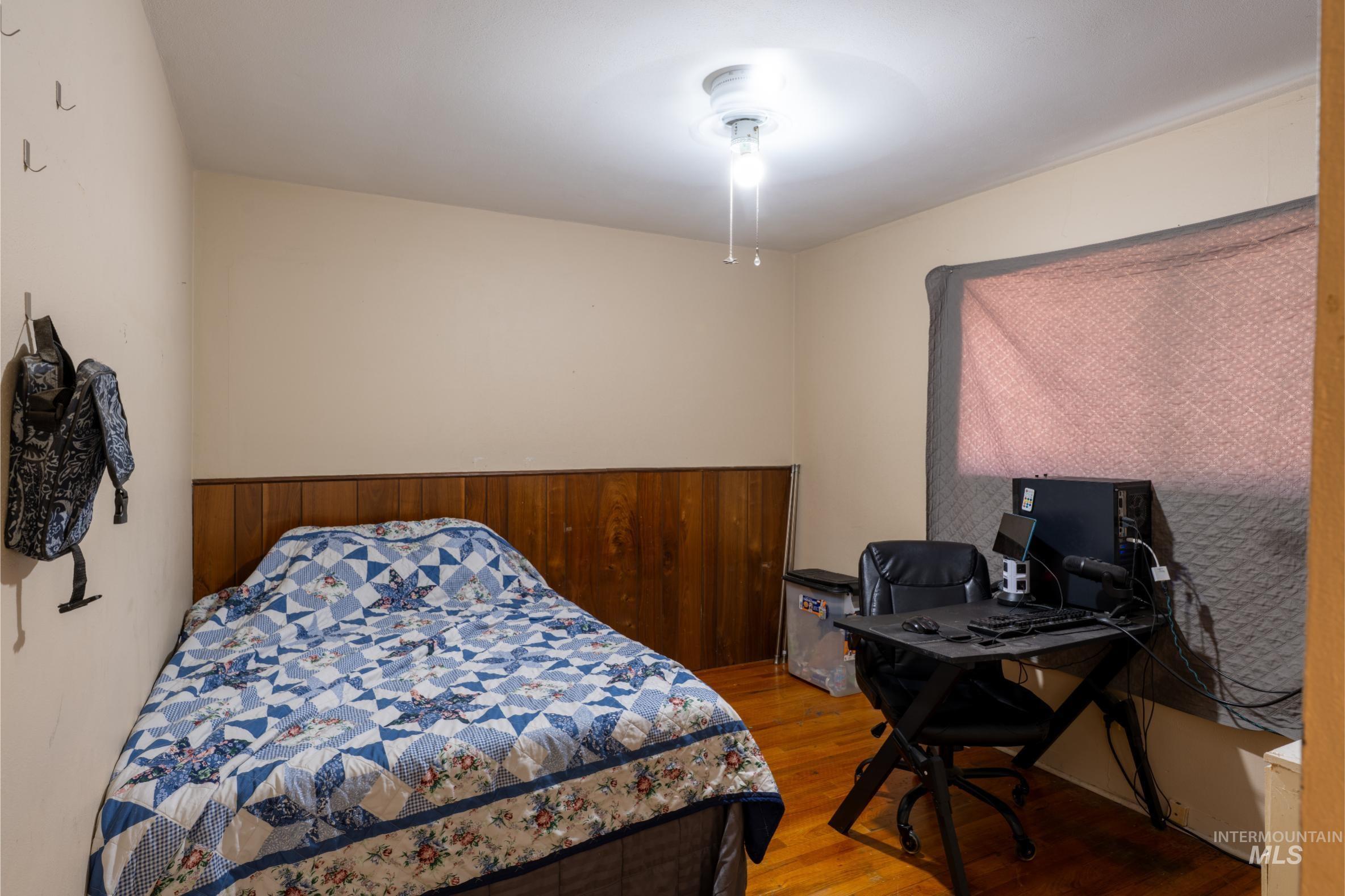 Bedroom featuring wood finished floors and a desk