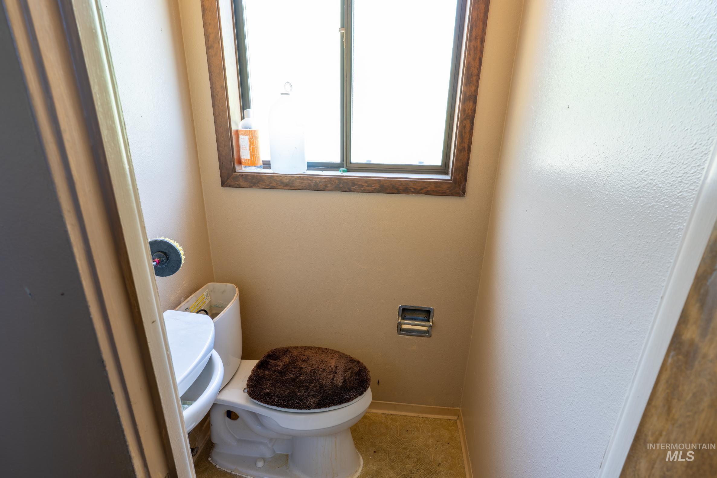 Half bath with toilet and a textured wall