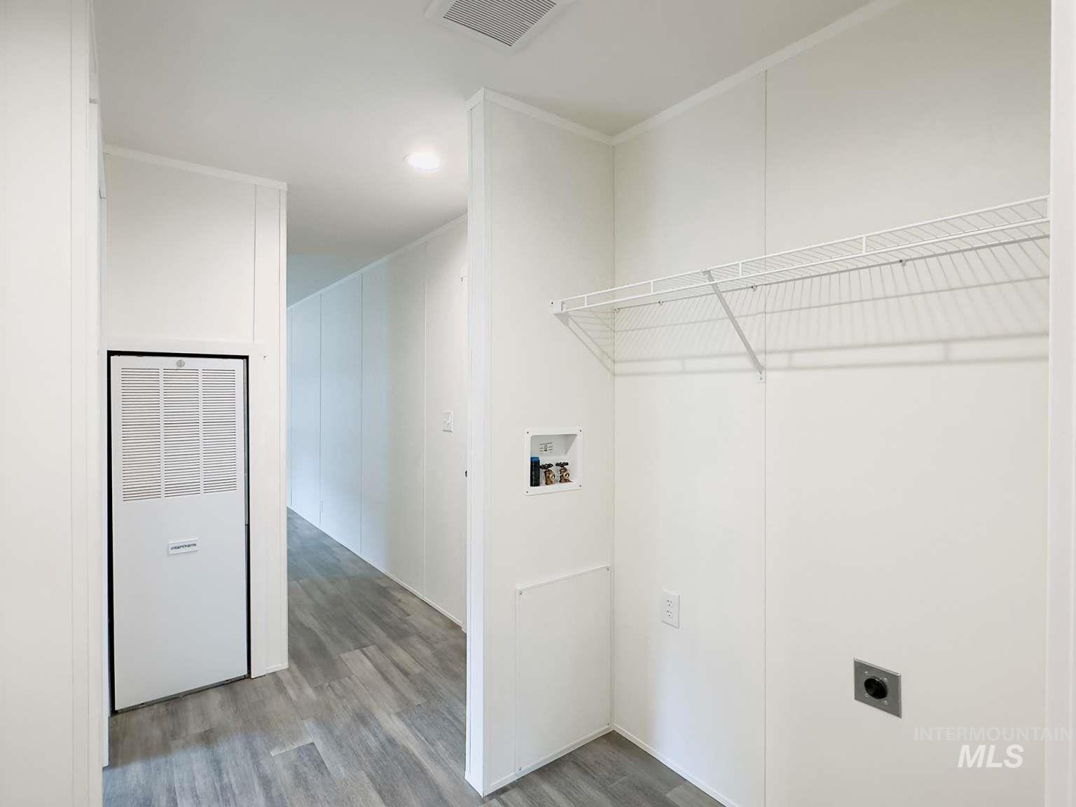 Washroom with wood finished floors, a heating unit, hookup for a washing machine, and recessed lighting