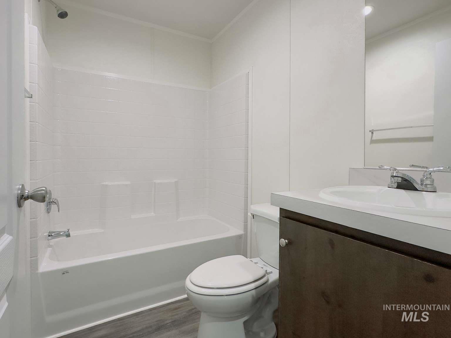 Bathroom with shower / bath combination, vanity, and dark wood-style floors