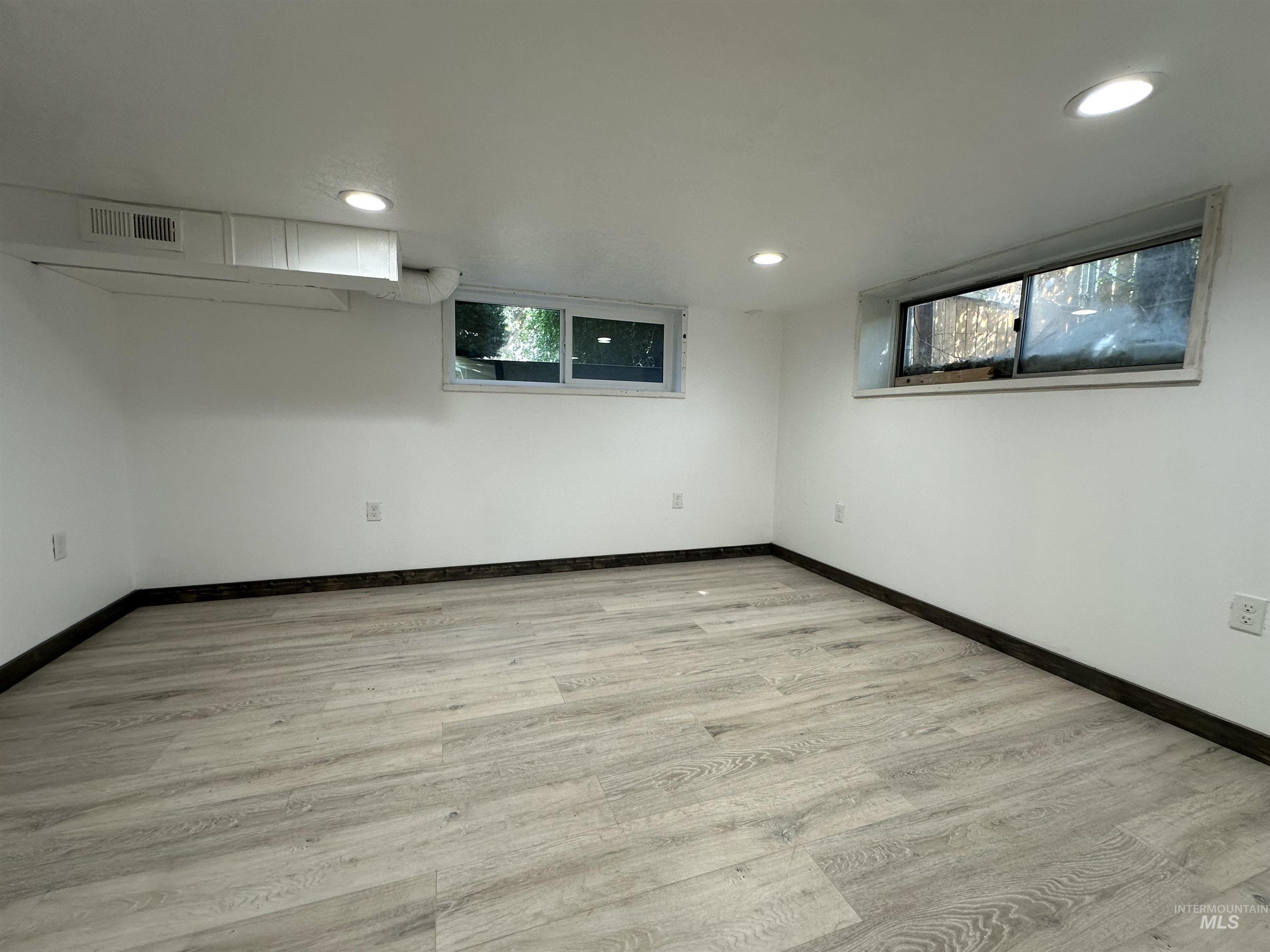 Below grade area featuring recessed lighting and light wood-style flooring