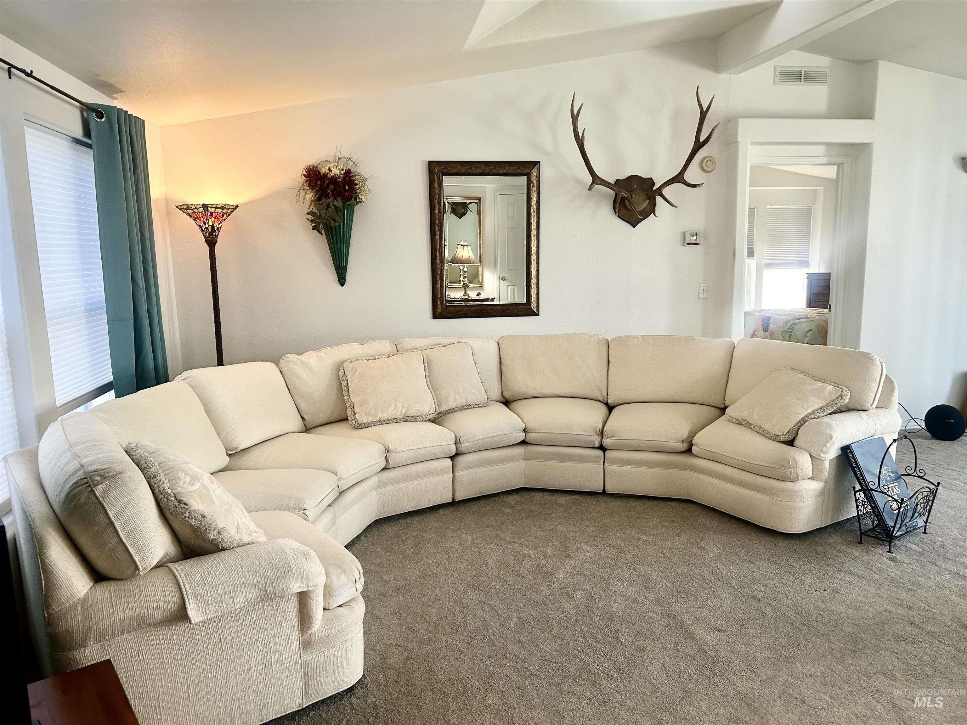 Living area featuring carpet flooring and beam ceiling