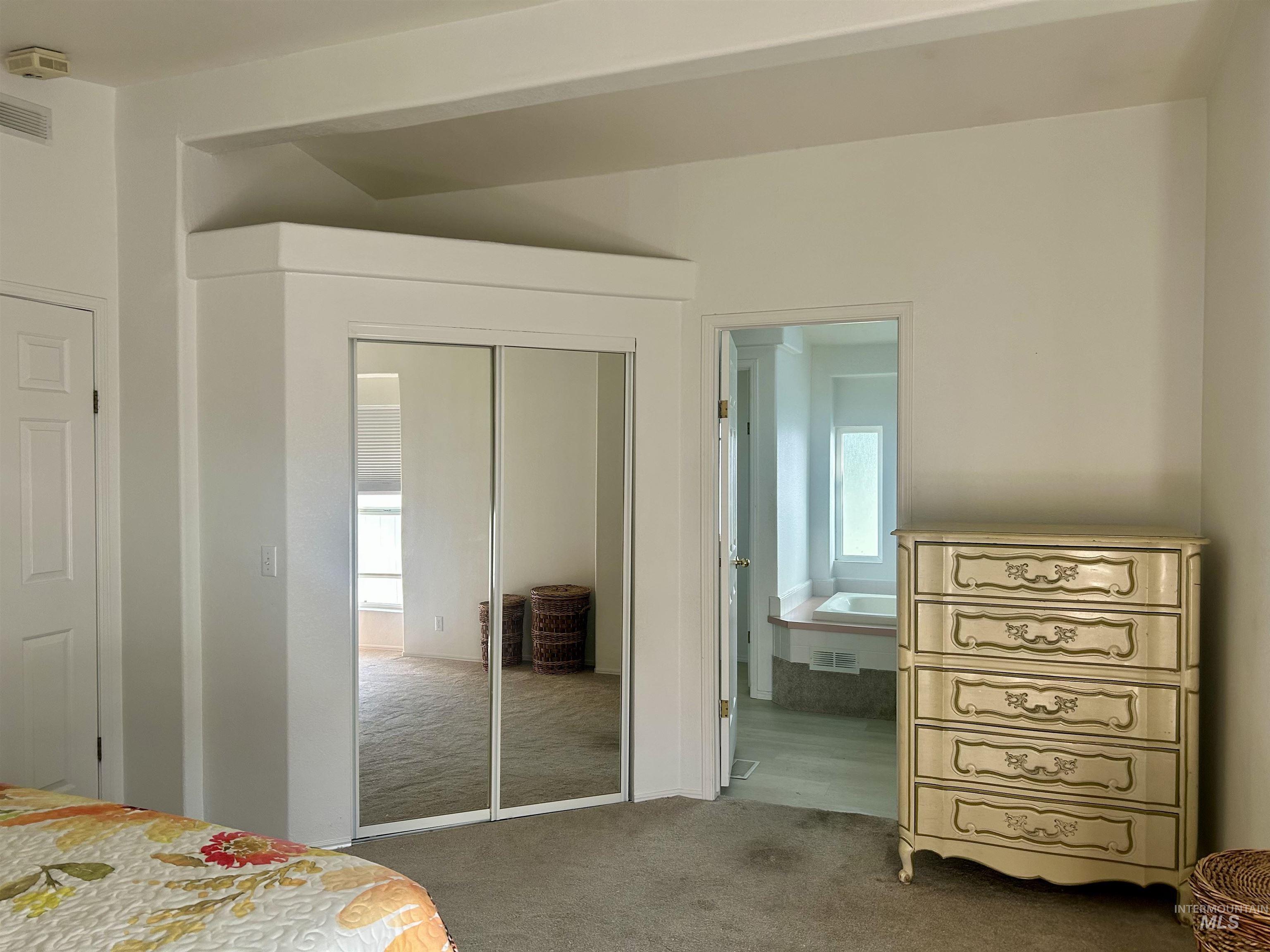 Carpeted bedroom with a closet and ensuite bathroom