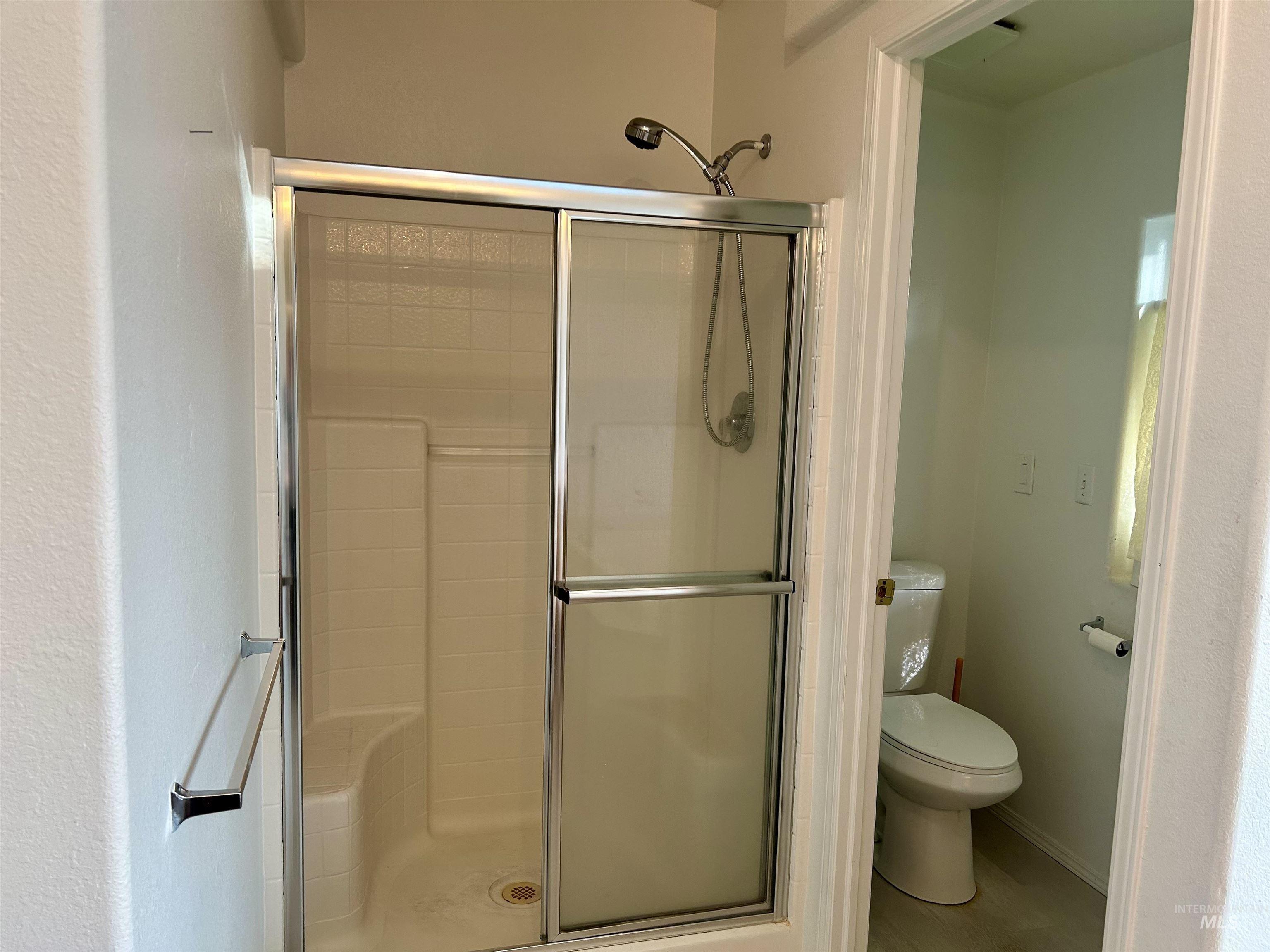 Full bath with a stall shower and toilet