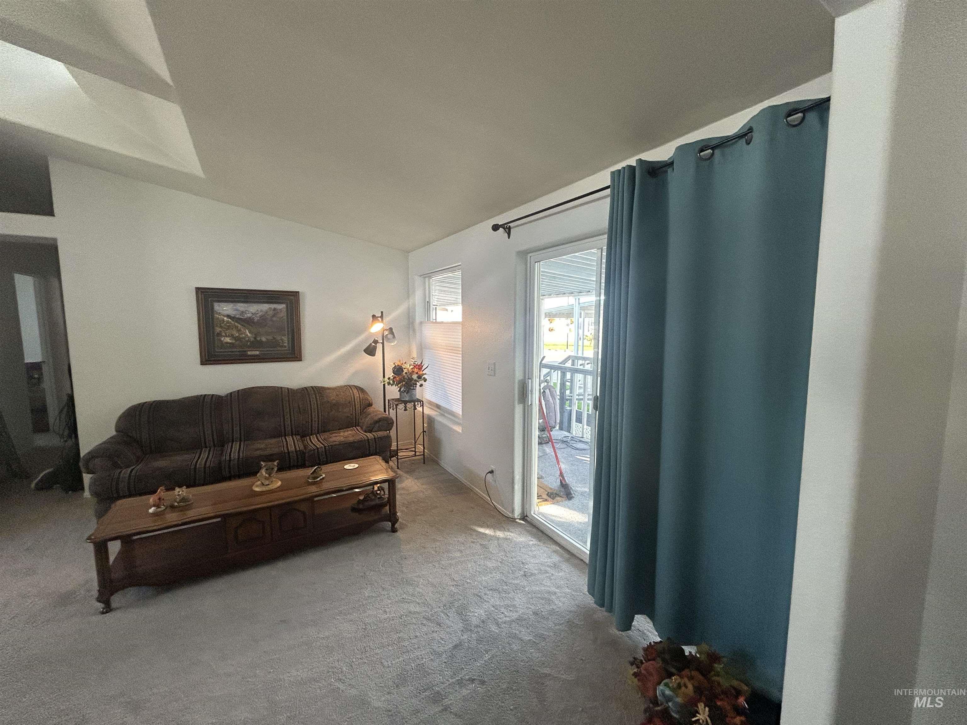 Carpeted living room with vaulted ceiling