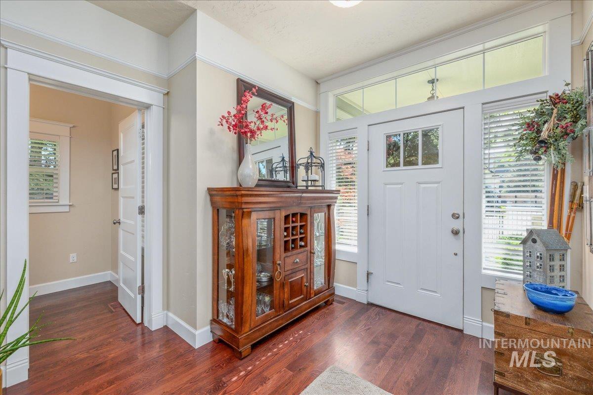 Entrance foyer with baseboards and dark wood-style floors
