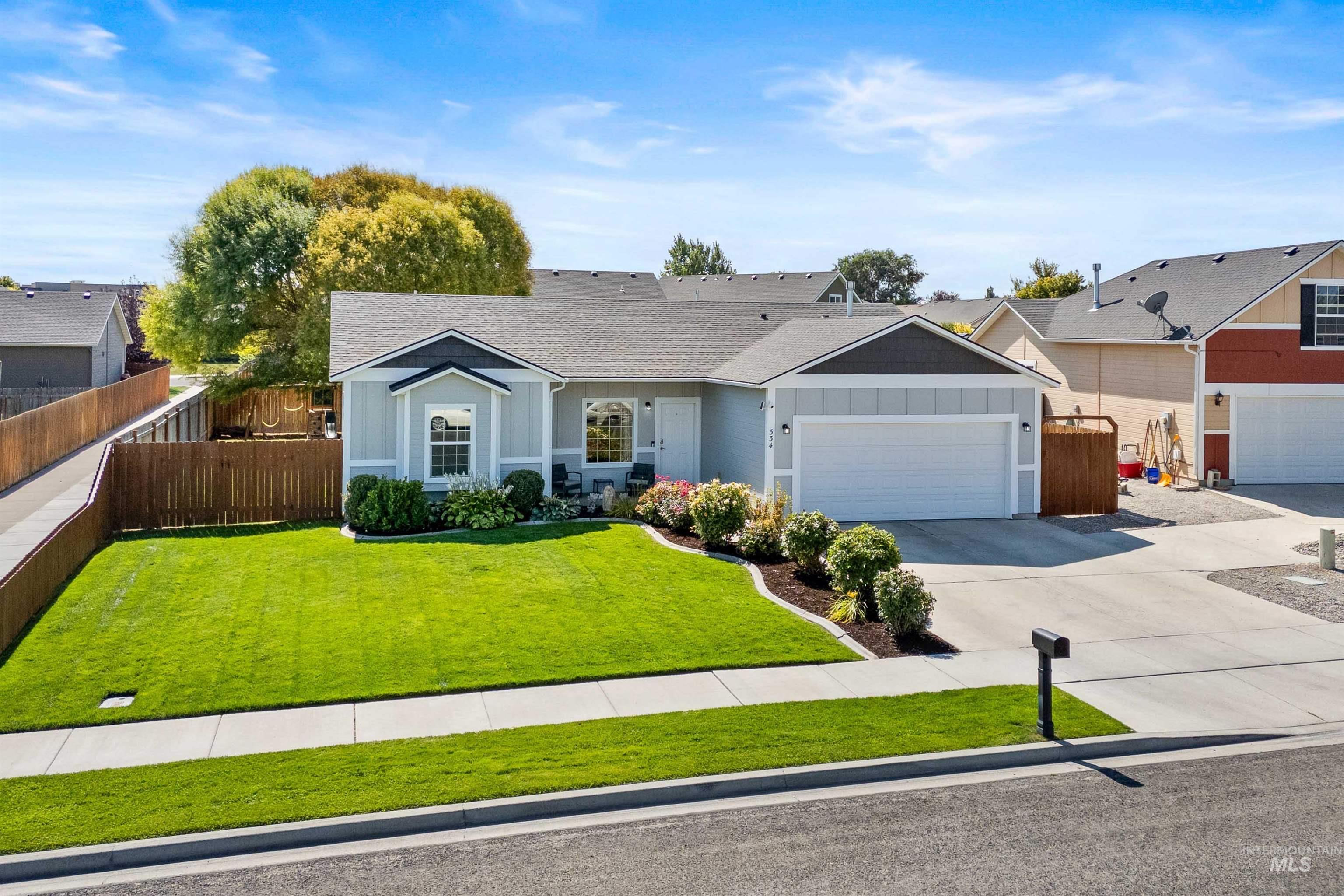 Ranch-style house with board and batten siding, a shingled roof, driveway, and an attached garage
