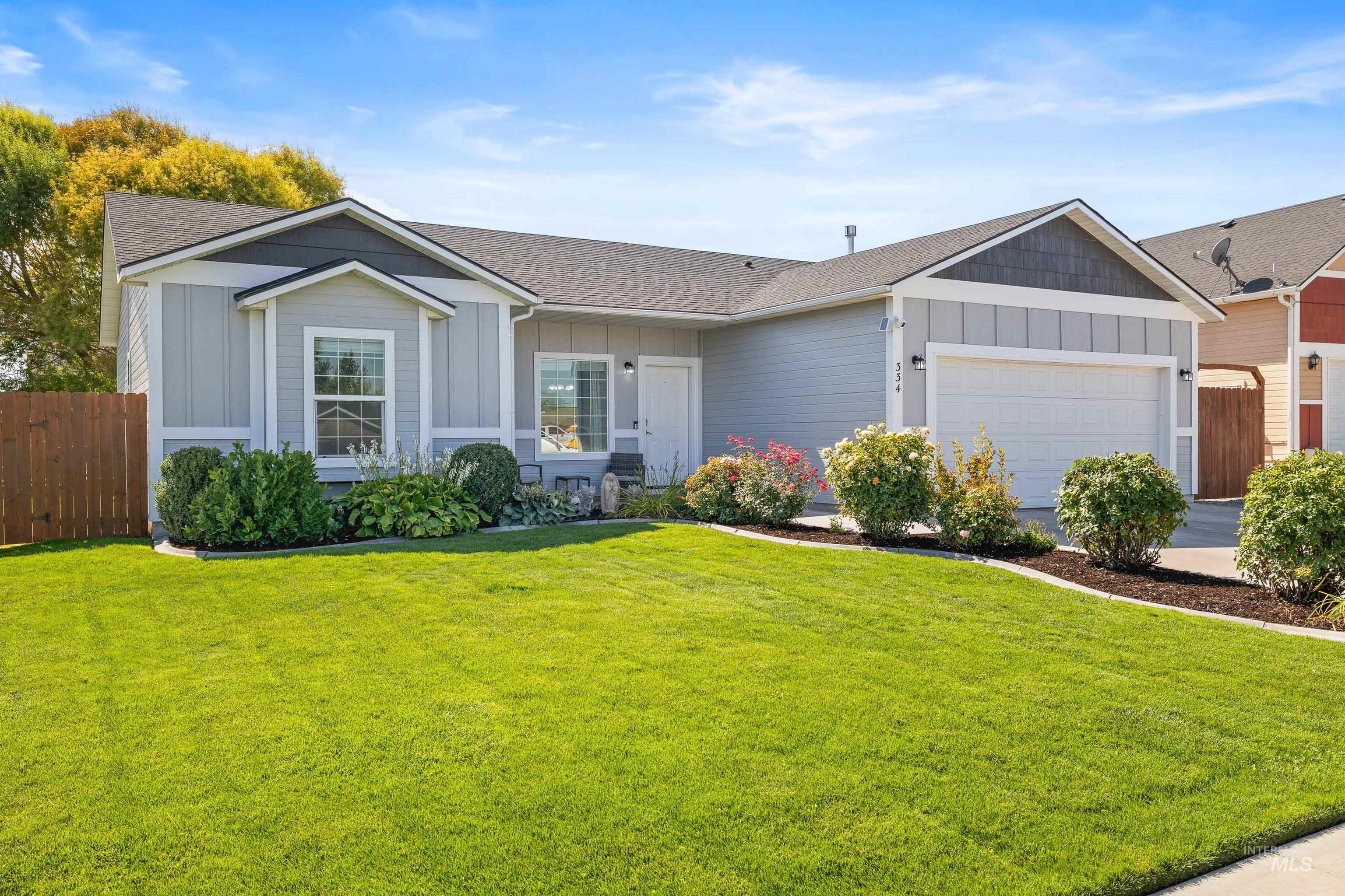Single story home featuring board and batten siding, a shingled roof, and a garage