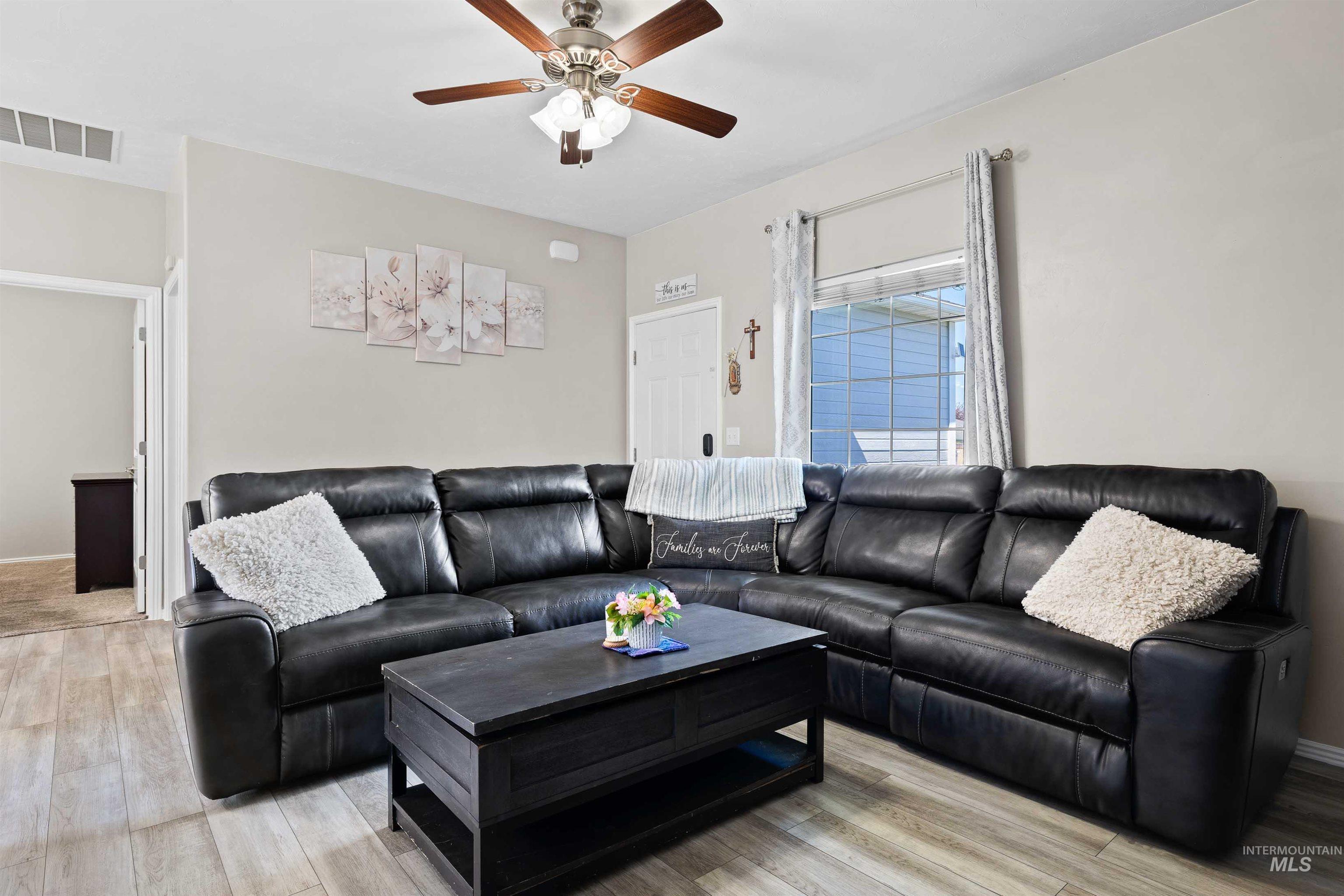 Living area featuring light wood finished floors and a ceiling fan