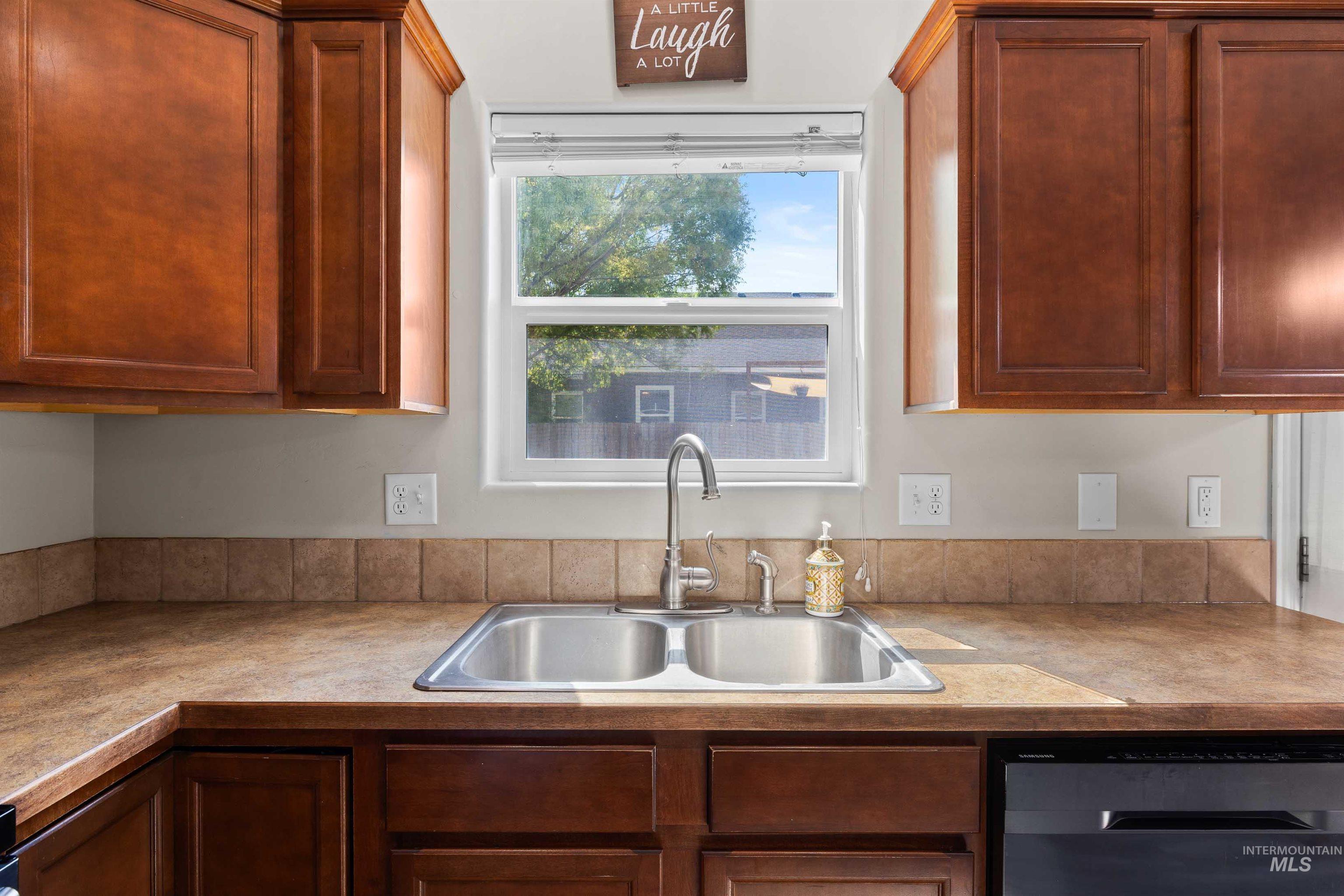 Kitchen featuring dishwasher and light countertops
