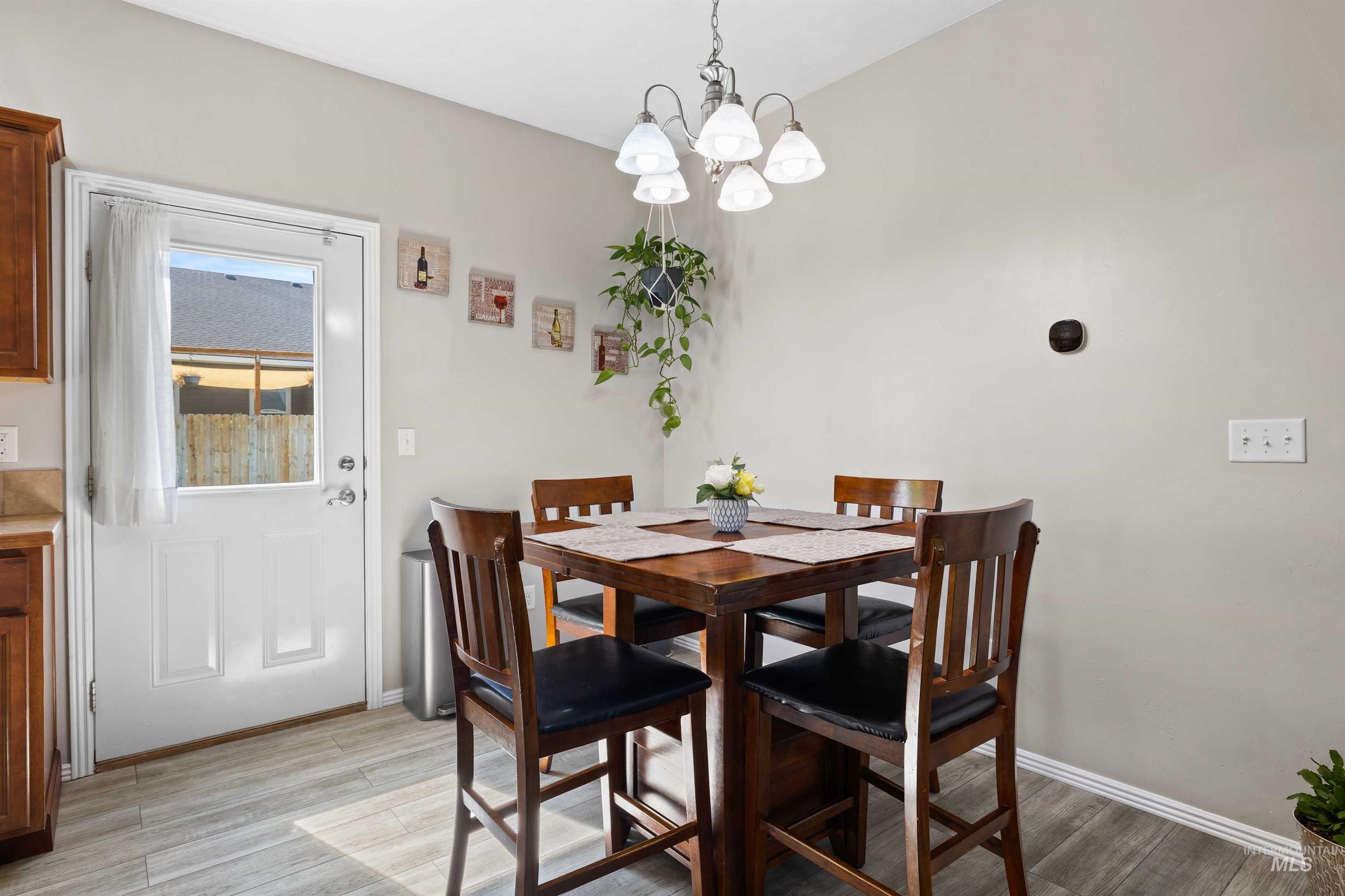 Dining space with light wood finished floors and a chandelier