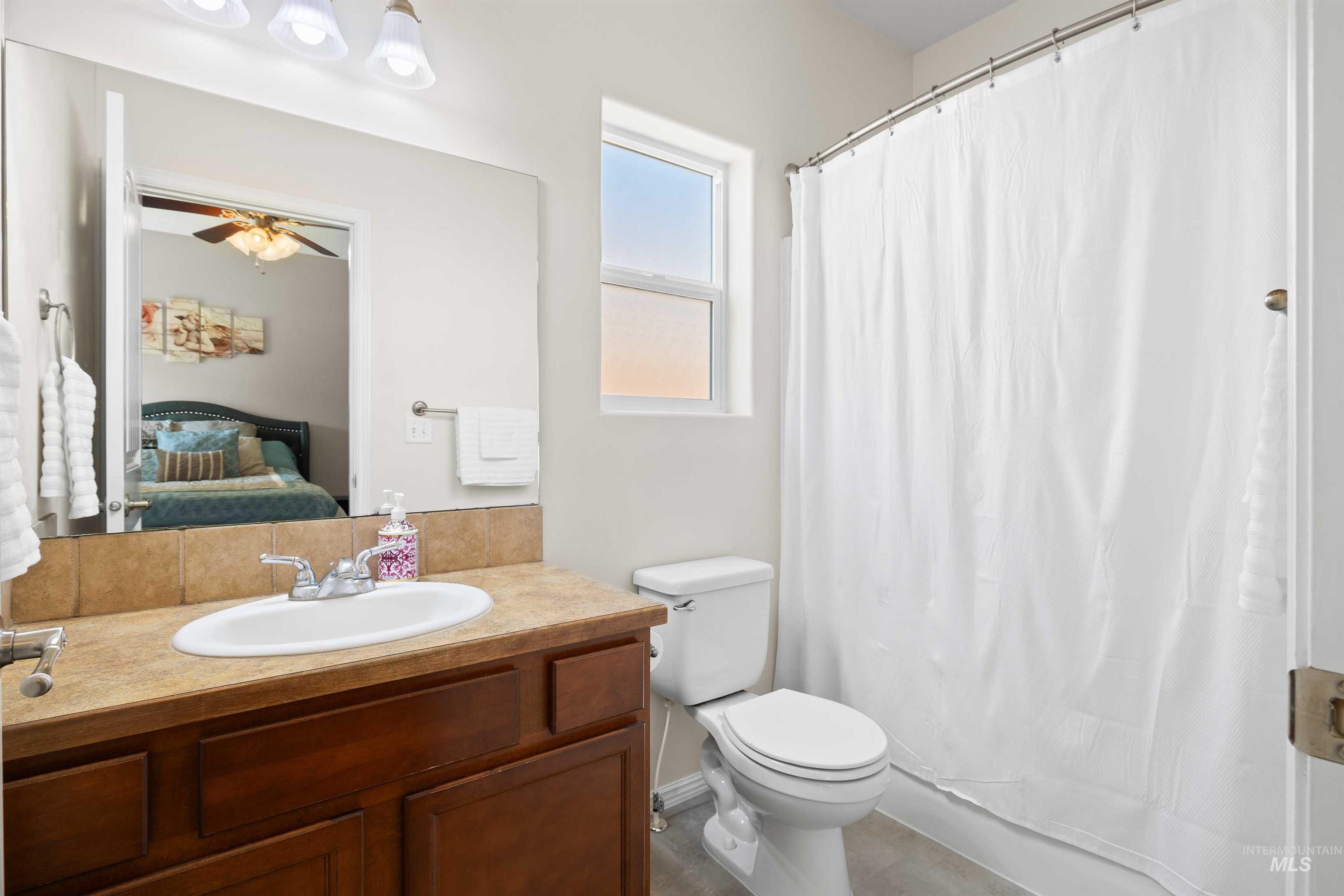 Bathroom featuring vanity, connected bathroom, and ceiling fan