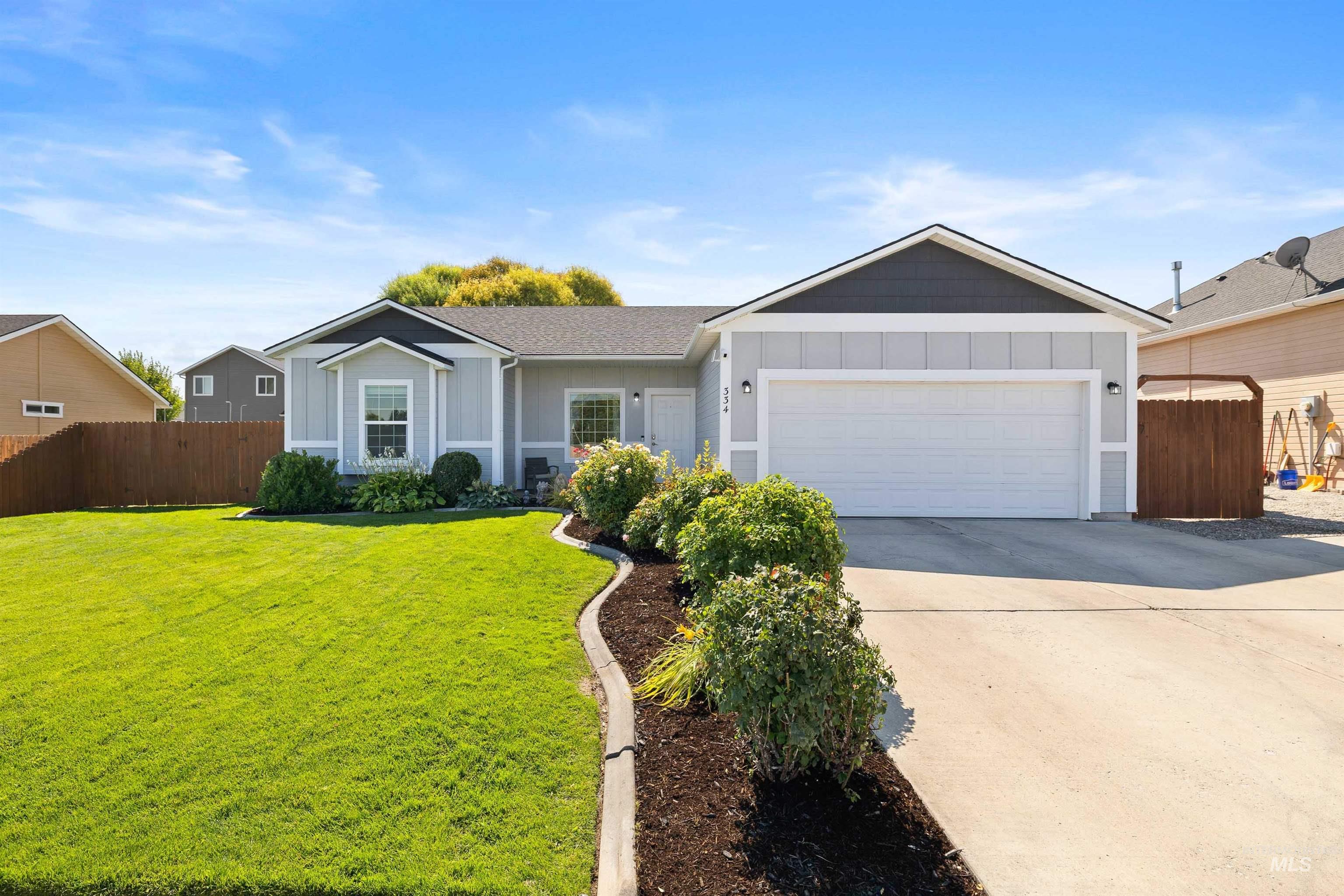 Ranch-style house with board and batten siding, driveway, and an attached garage
