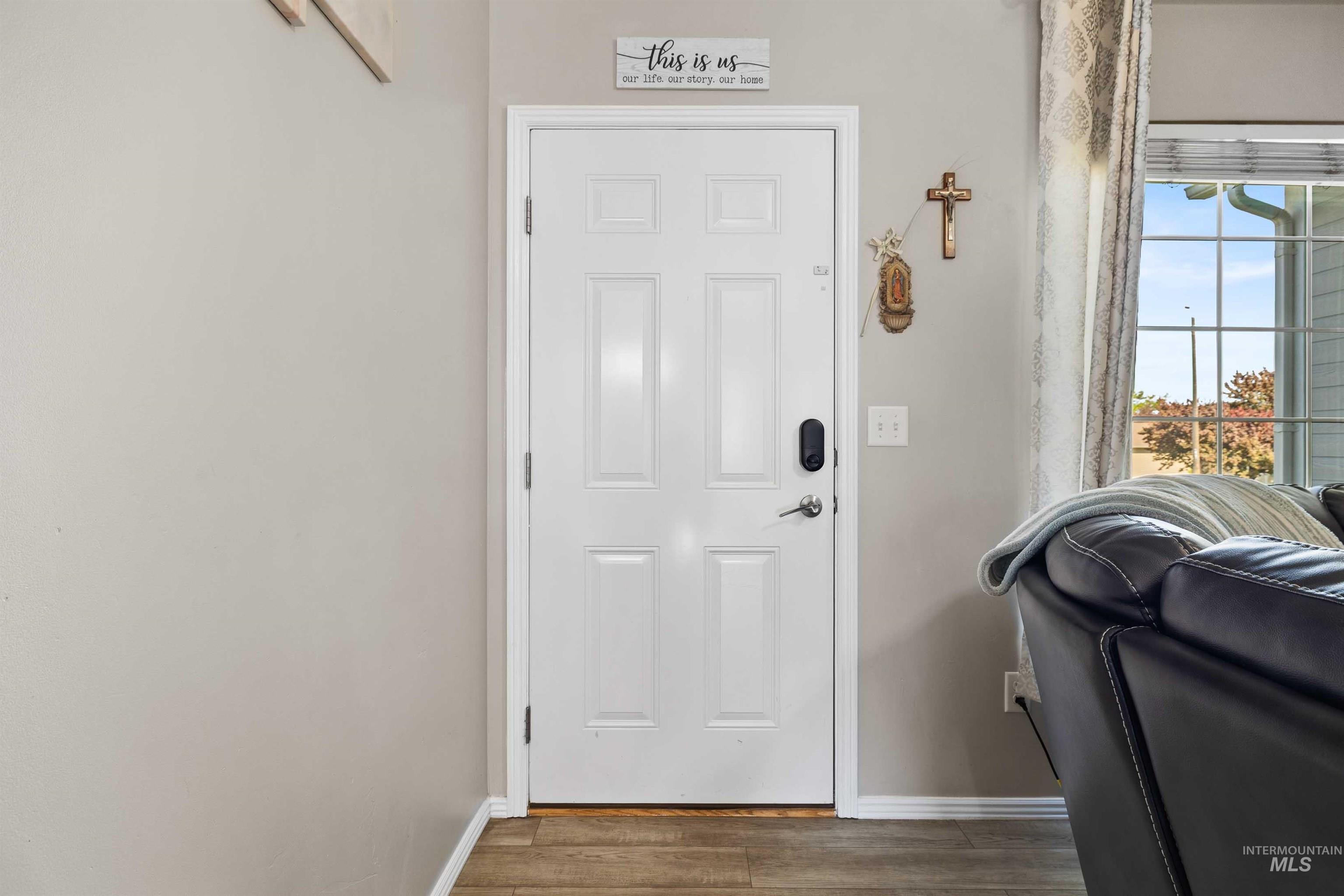 Doorway featuring baseboards and wood finished floors