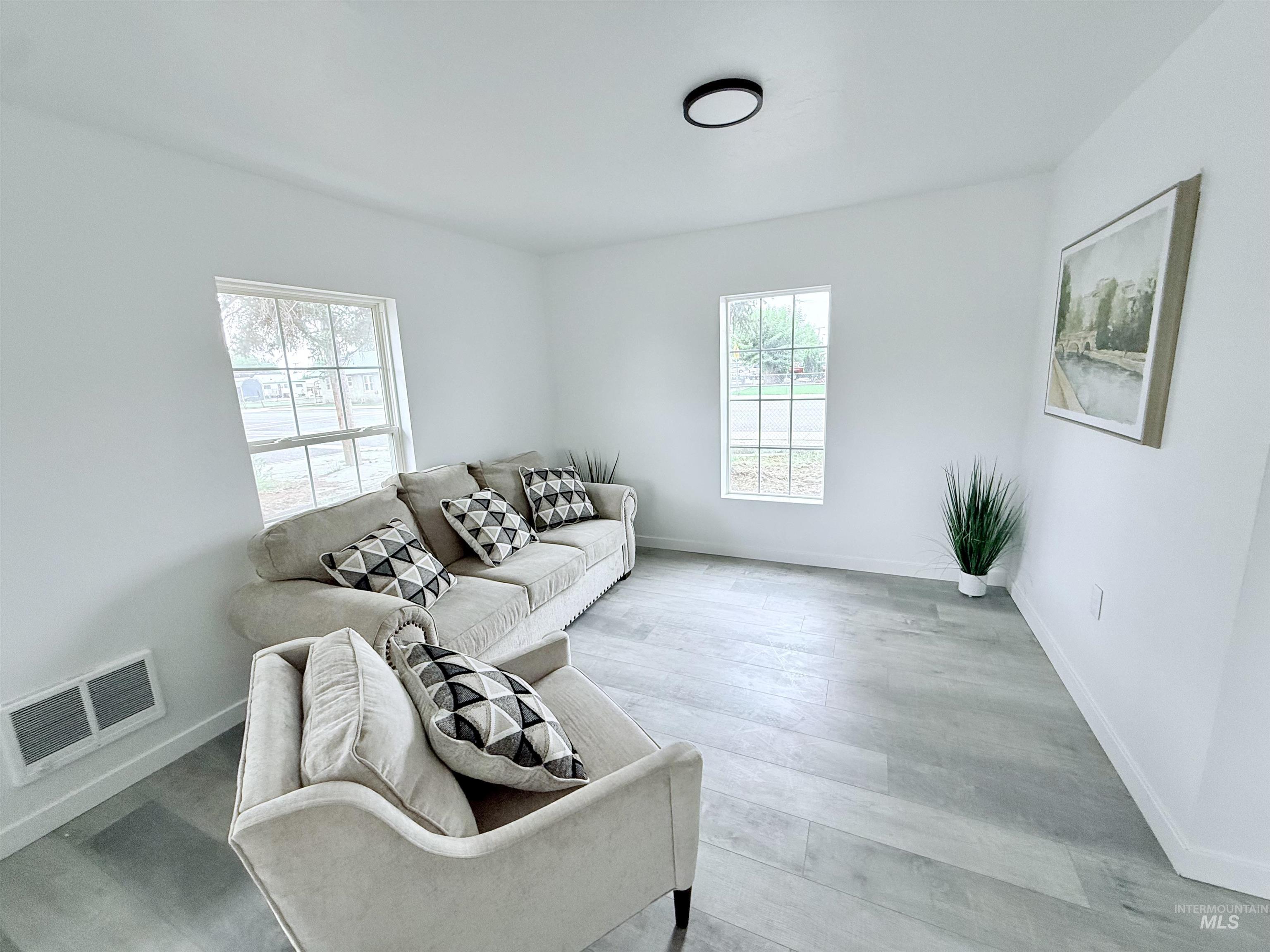 Living area with baseboards and wood finished floors