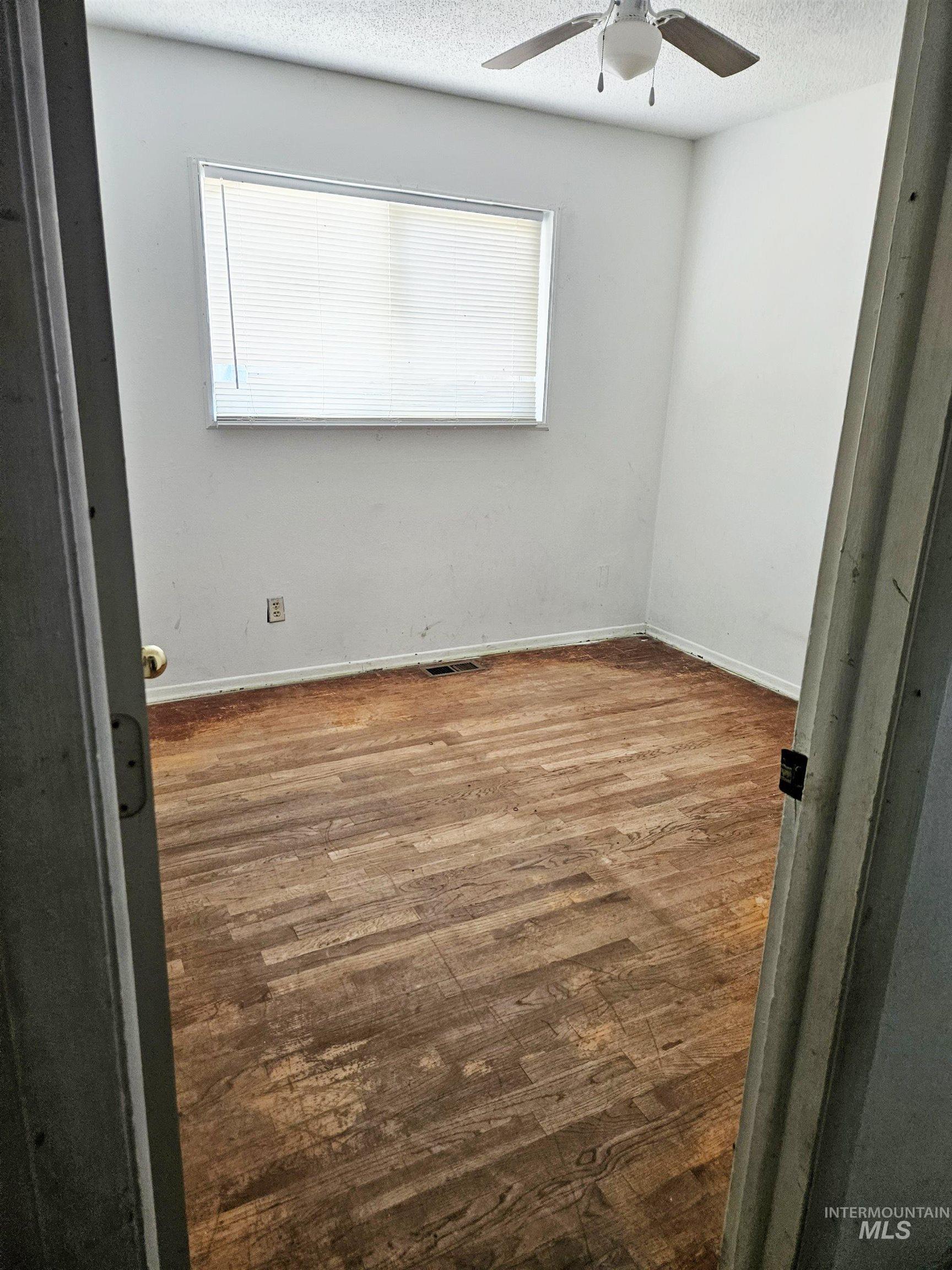Spare room featuring wood finished floors and a textured ceiling