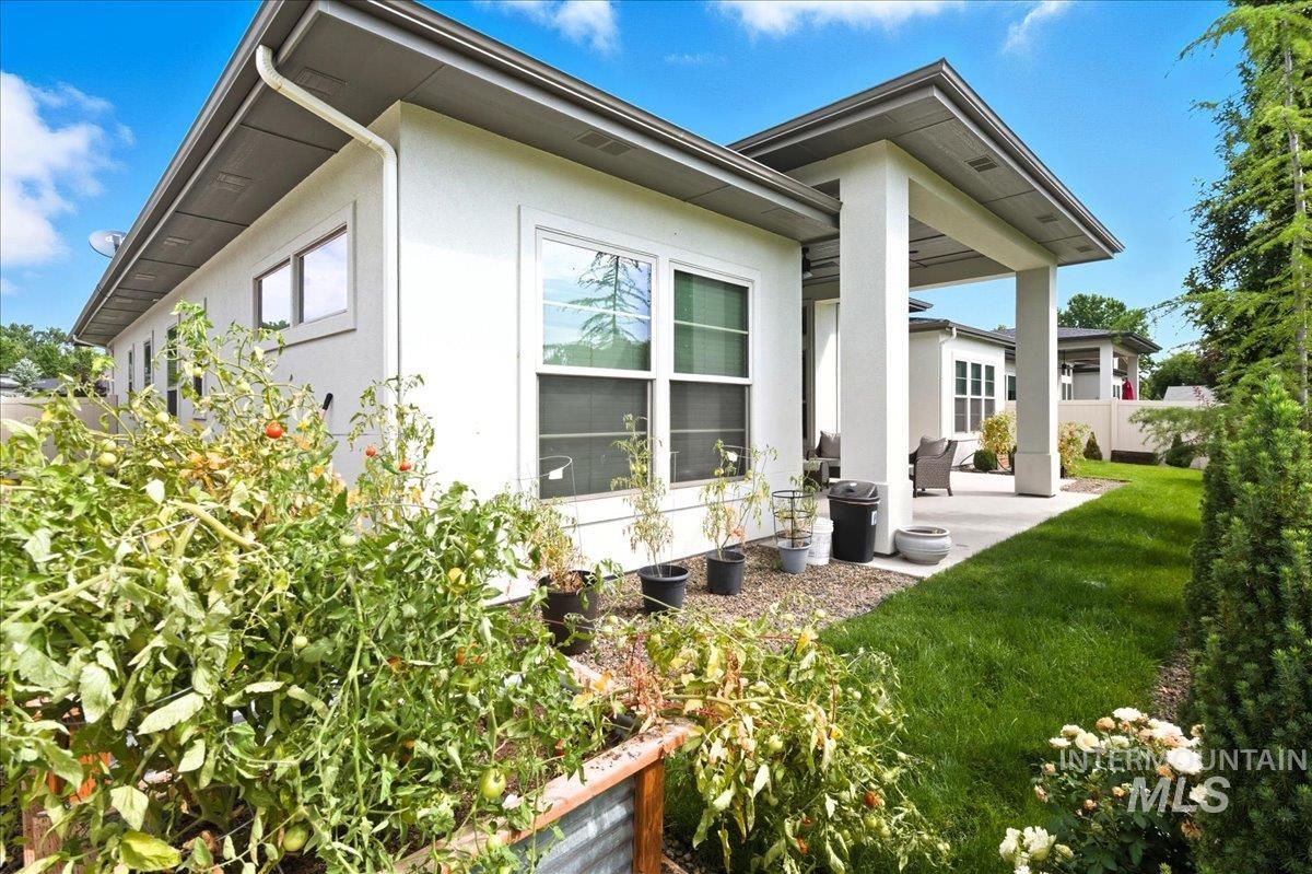 View of side of home featuring a patio, stucco siding, and a lawn