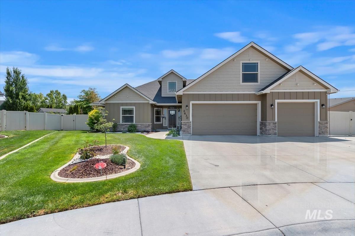 Craftsman-style house with board and batten siding, stone siding, and driveway