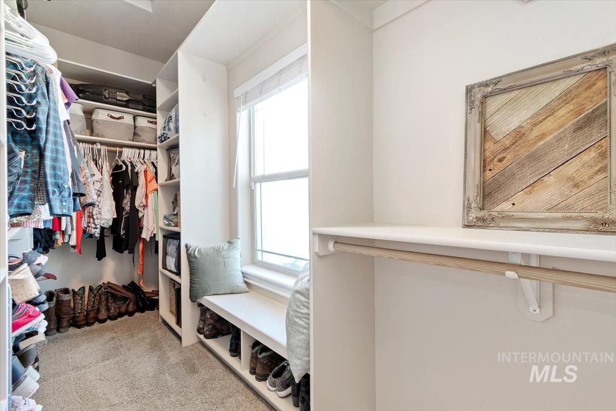 Spacious closet with light carpet