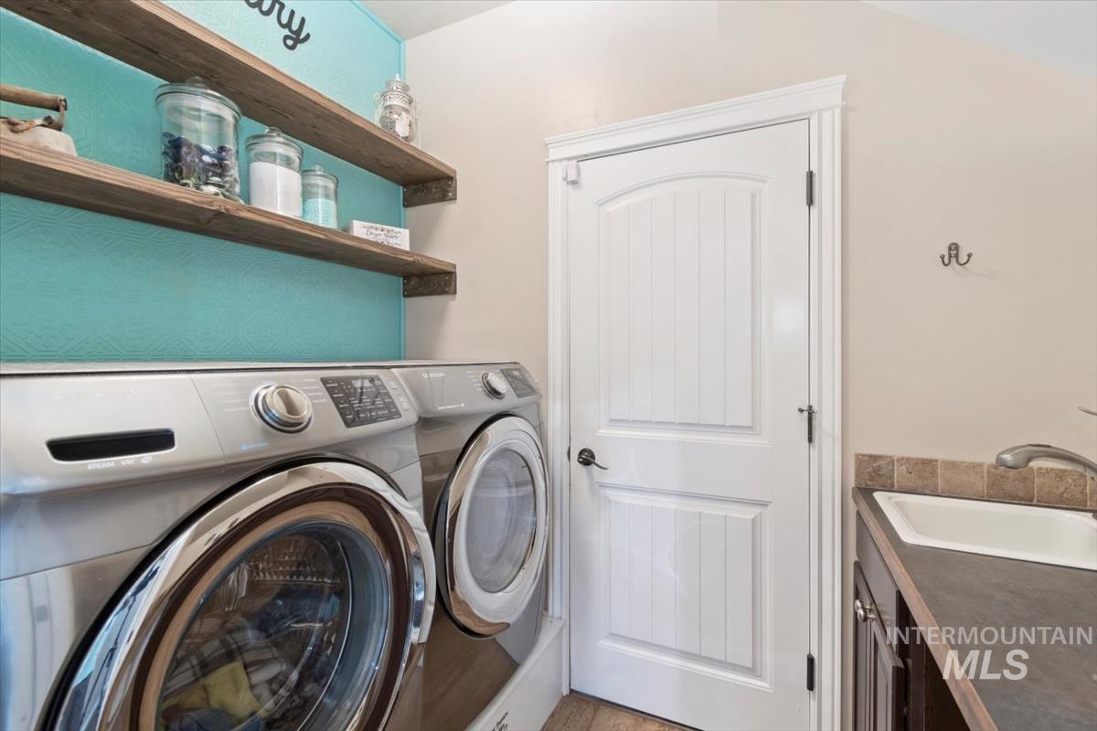 Laundry room with separate washer and dryer and a sink