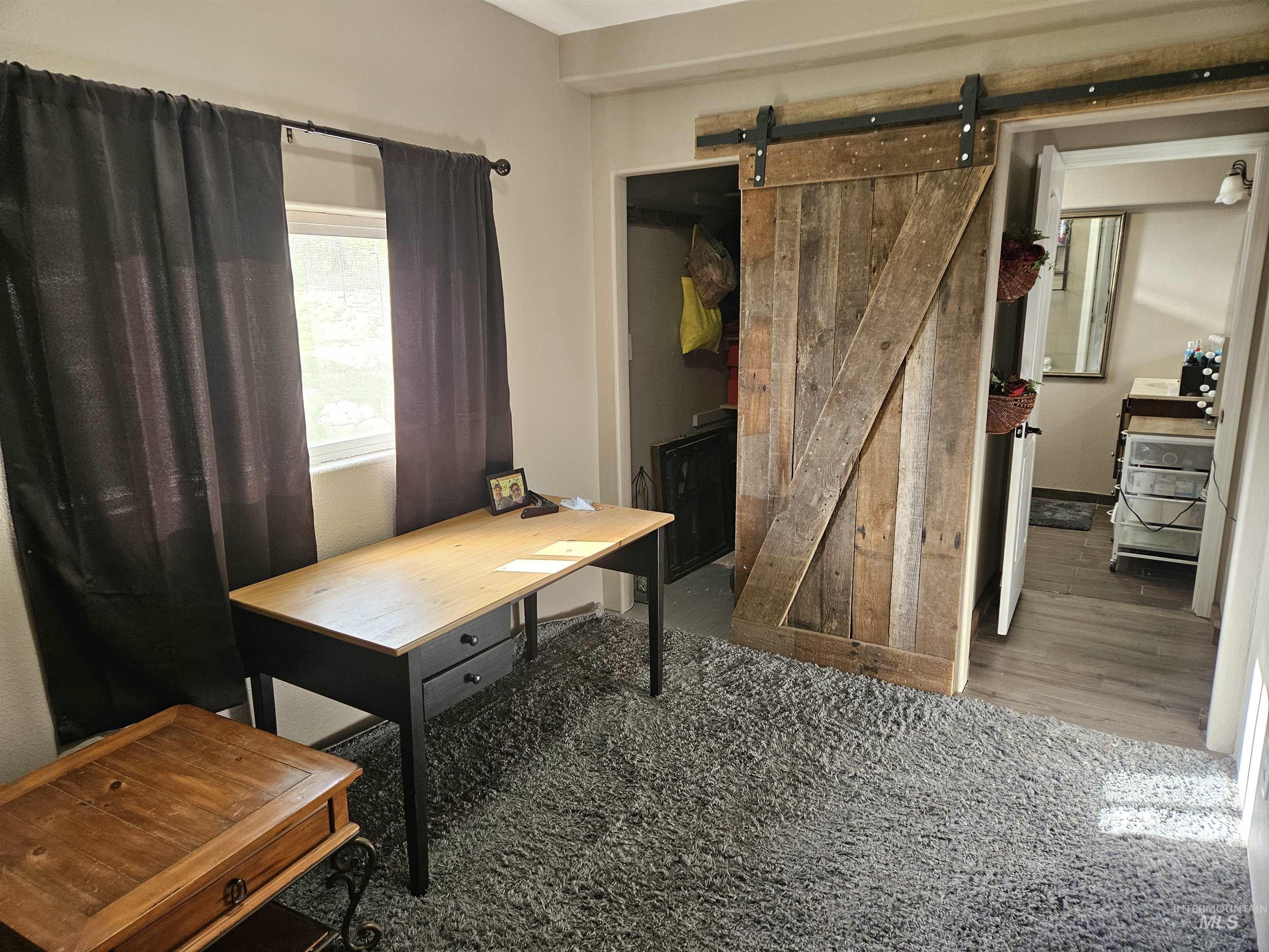Office space featuring carpet floors and a barn door
