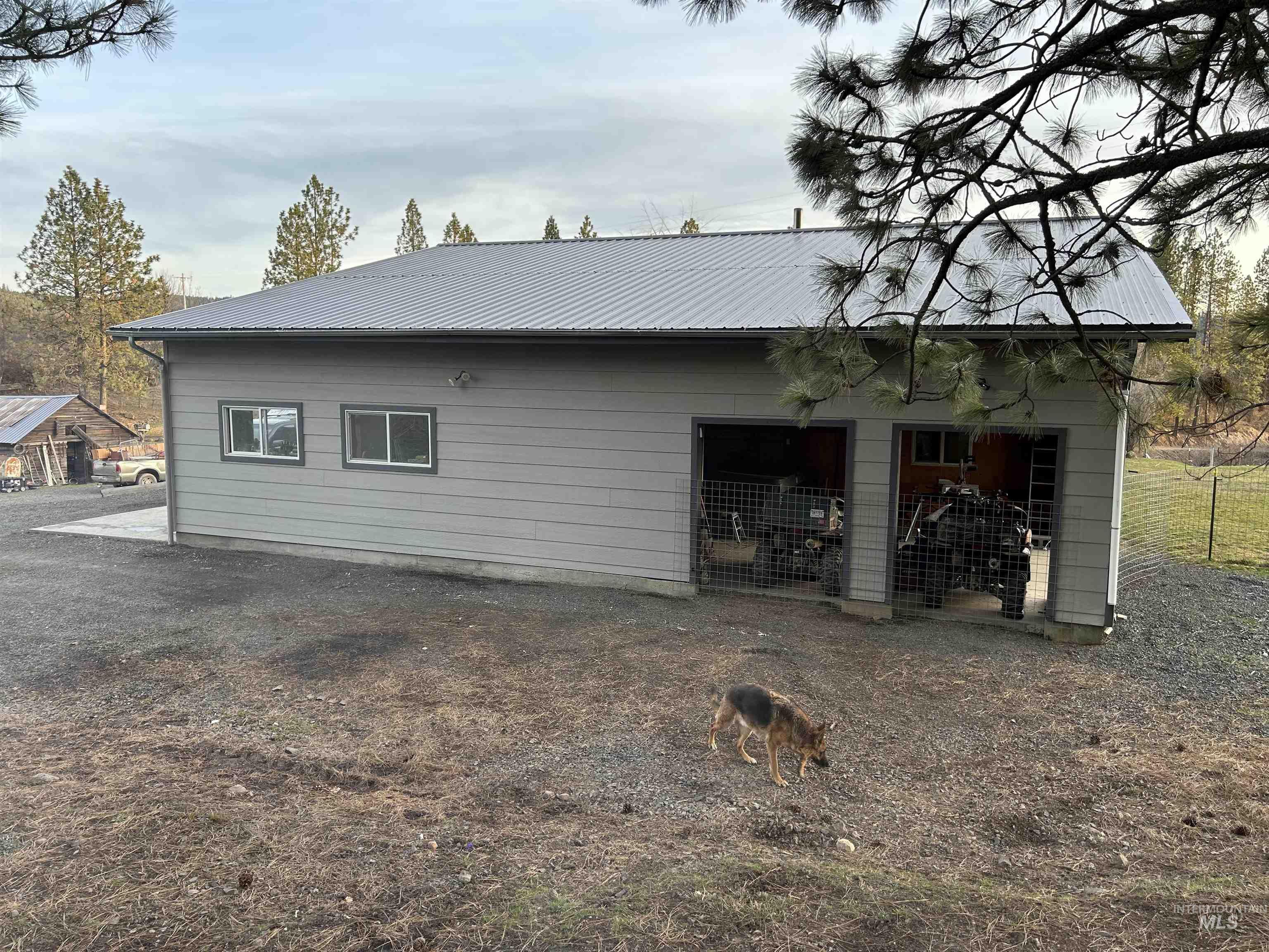 View of property exterior featuring a metal roof and an outbuilding