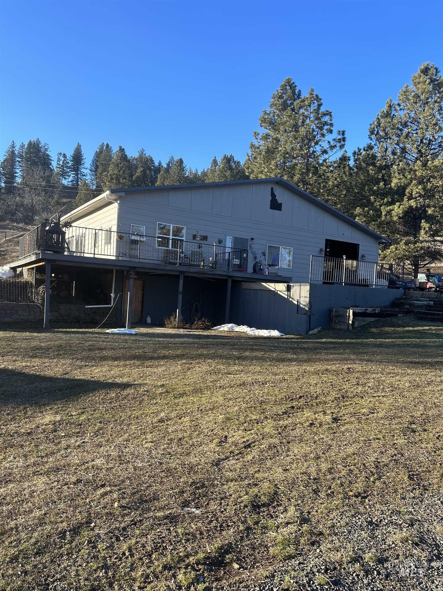Back of property with a wooden deck and a lawn