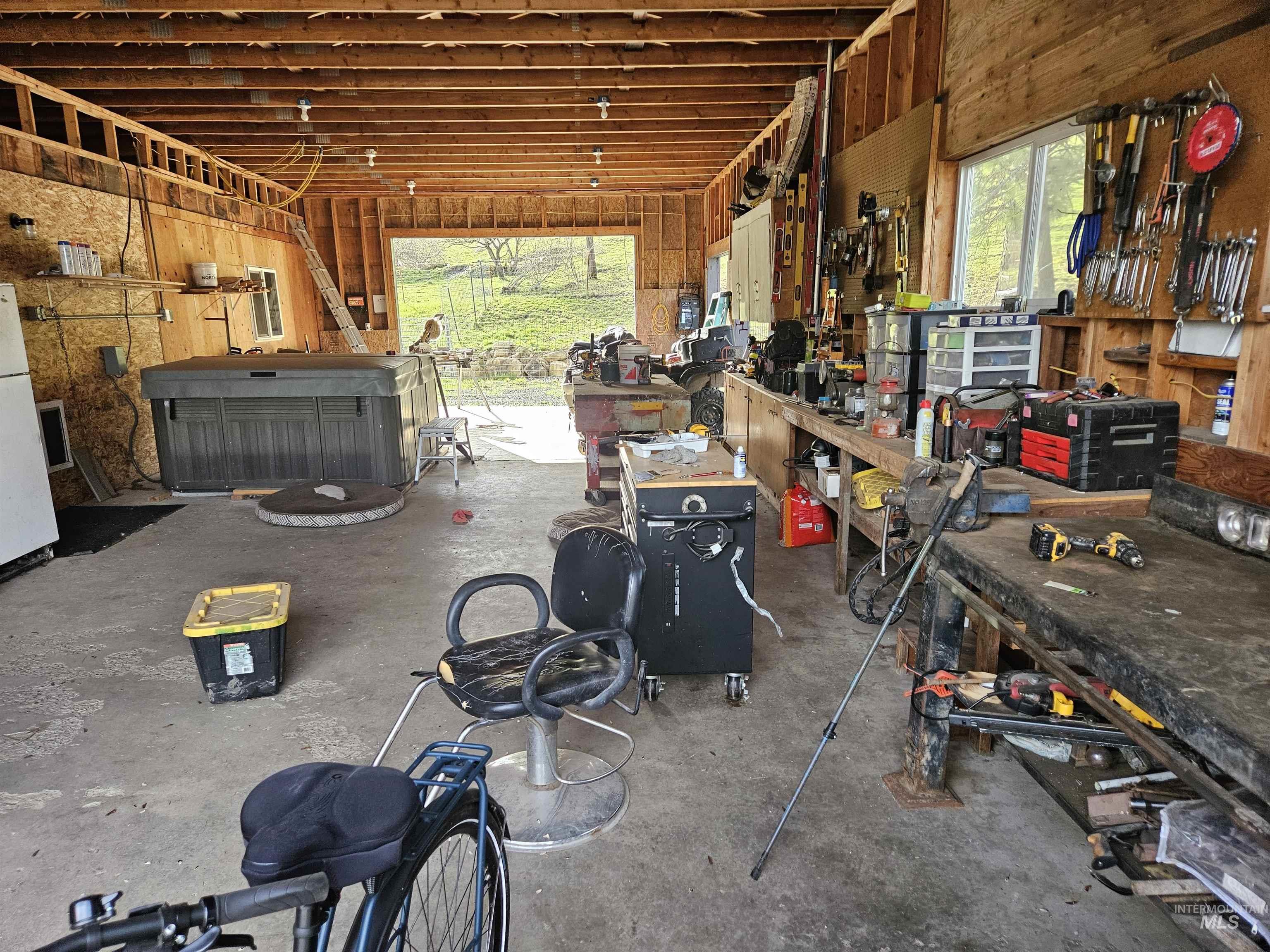Garage featuring a workshop area and freestanding refrigerator
