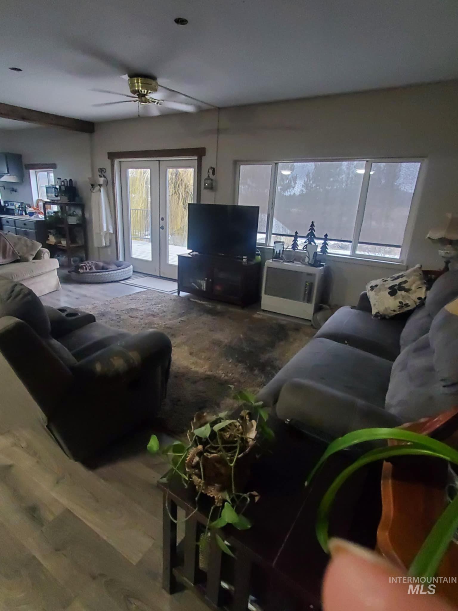 Living area featuring wood finished floors, french doors, and ceiling fan